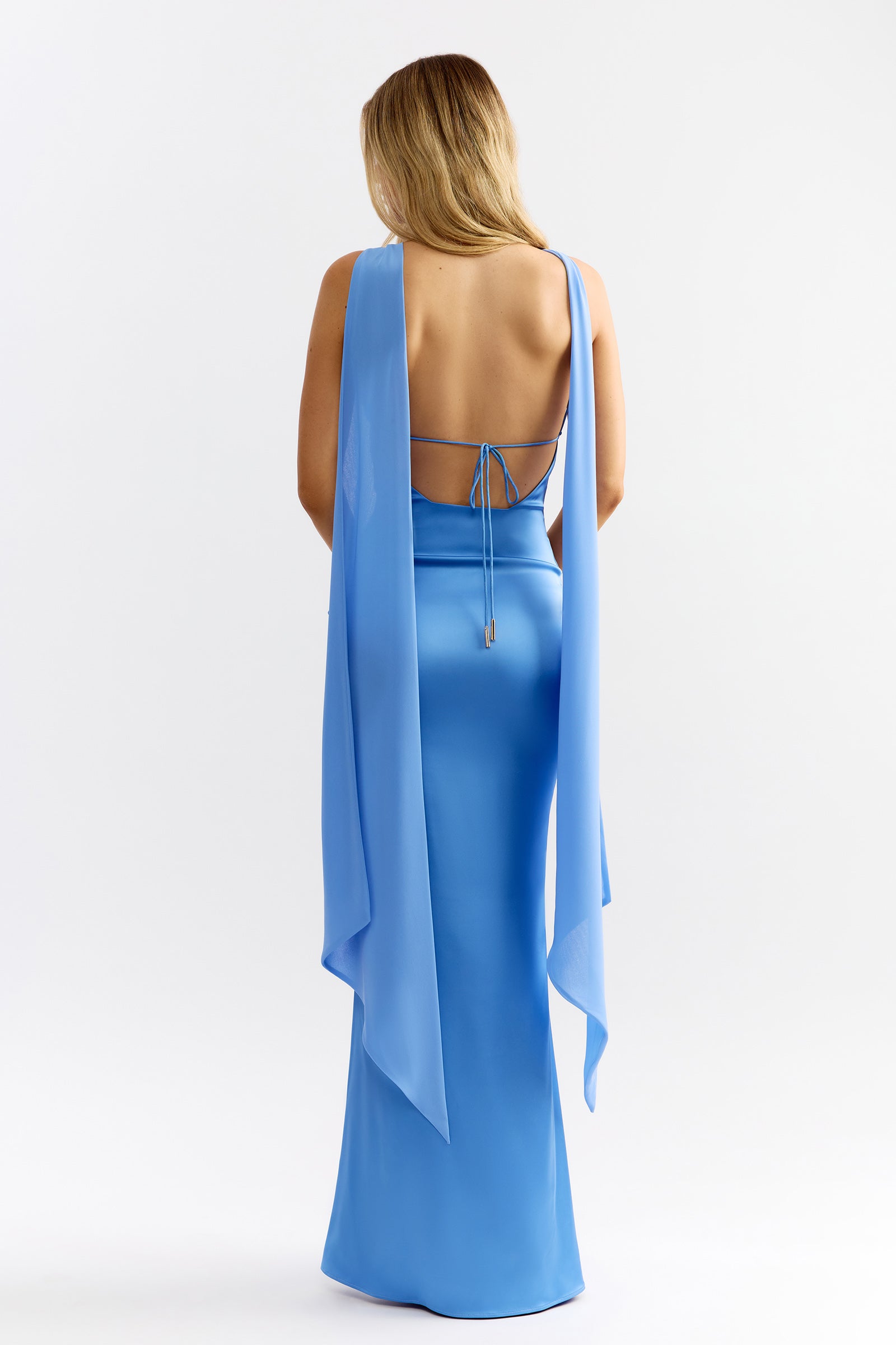 Audrey Dress featuring a sleek backless silhouette with flowing shoulder drapes in ocean blue for formal and bridesmaid occasions