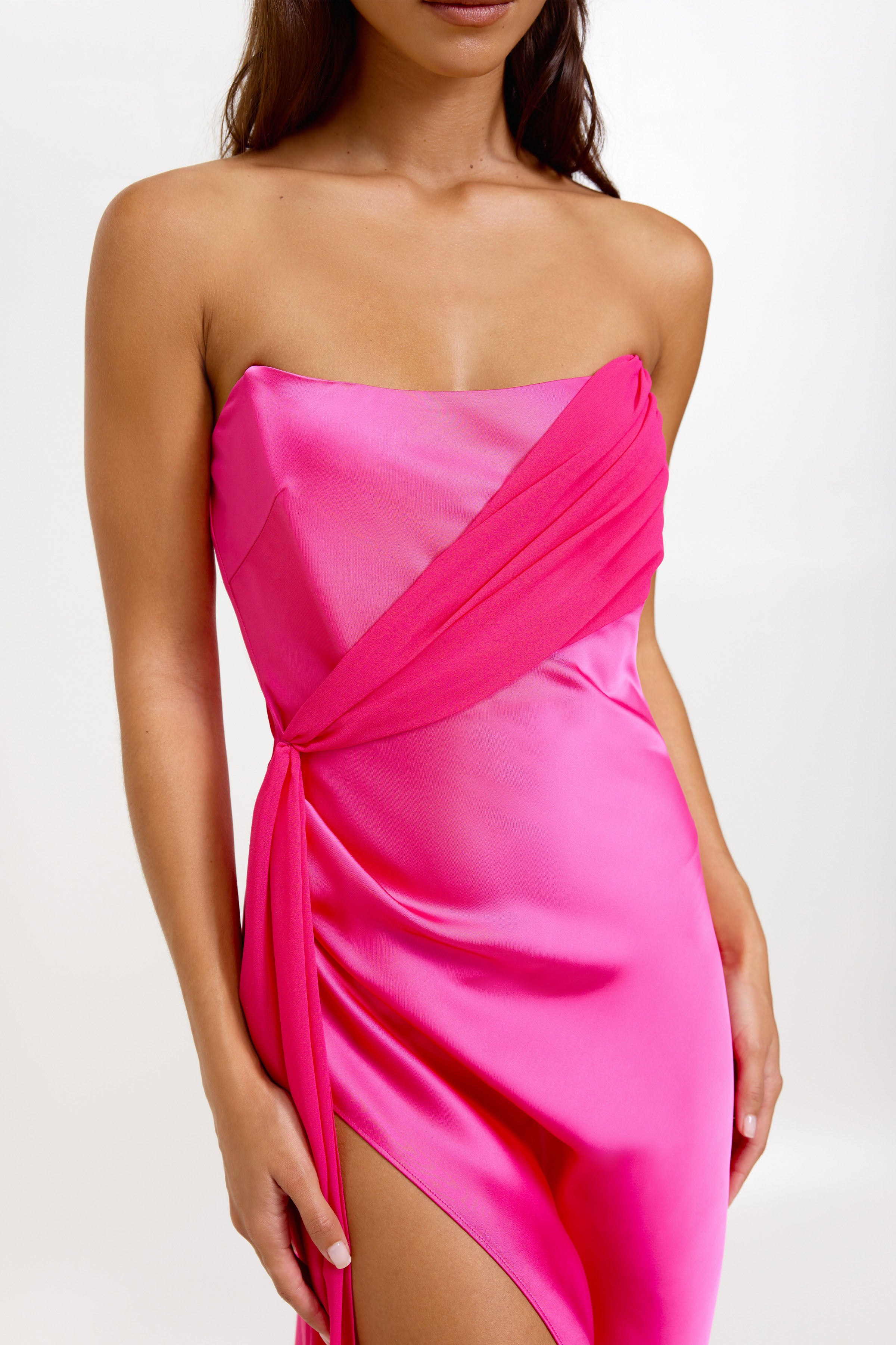 Aura Dress featuring a strapless bra-friendly satin silhouette with elegant draped detail in vibrant hot pink for formal occasions