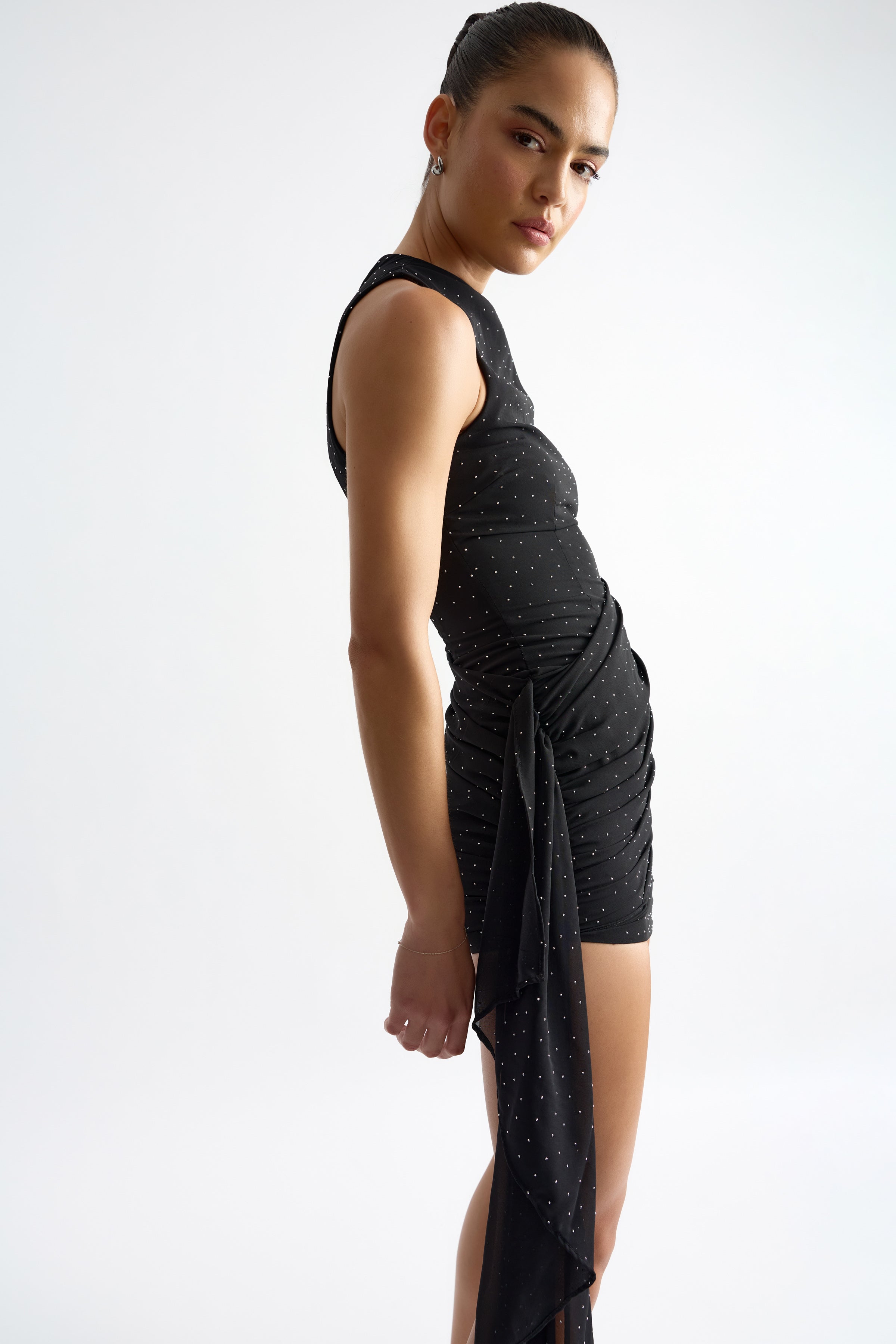 Avril Dress featuring a sleeveless, ruched silhouette with side tie detail in black with subtle embellishments by Studio Lexi