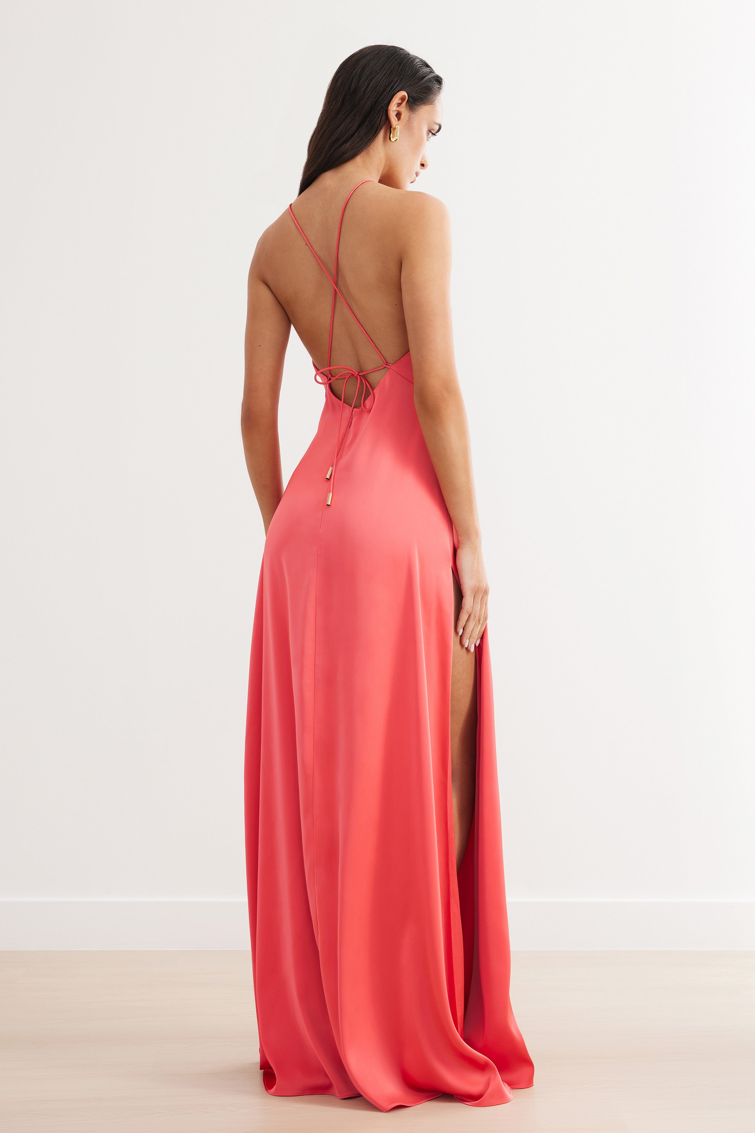 Bali Dress featuring a backless silhouette with crisscross straps and high side slit in flamingo satin for formal wear