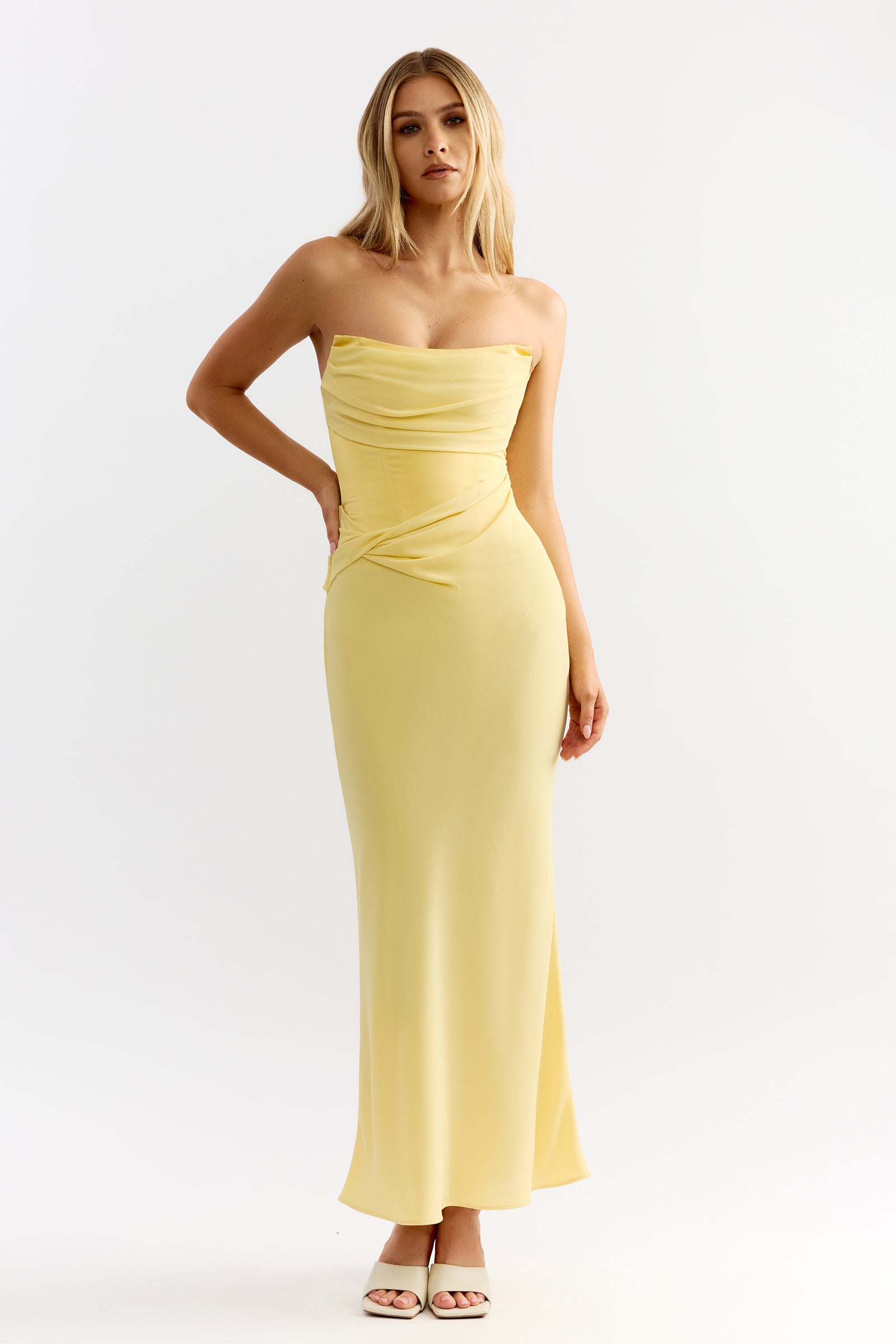Cassie Dress features a strapless cowl bodice and smooth silhouette in soft sunflower yellow by Studio Lexi