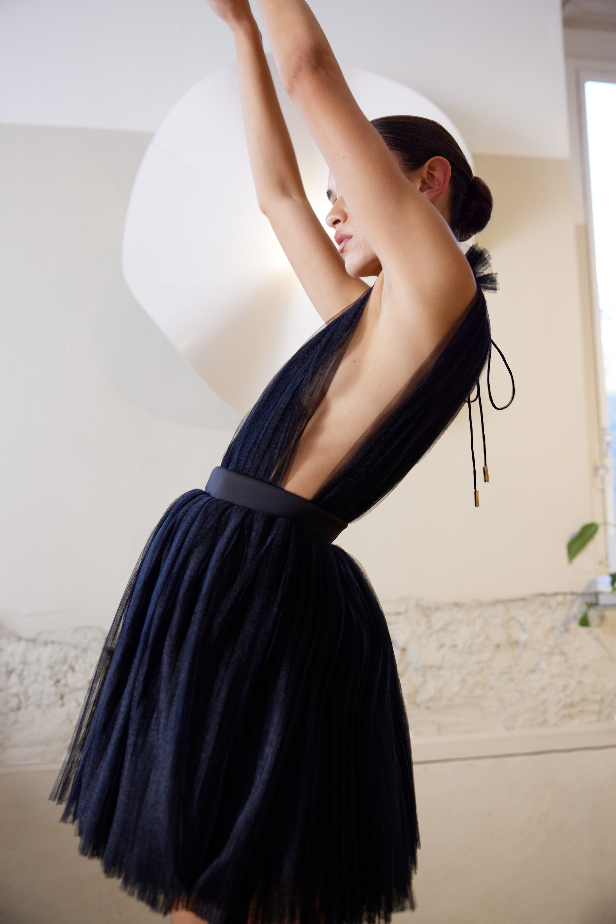 Charlize Dress featuring a pleated black tulle design with deep V-back for cocktail and wedding guest occasions