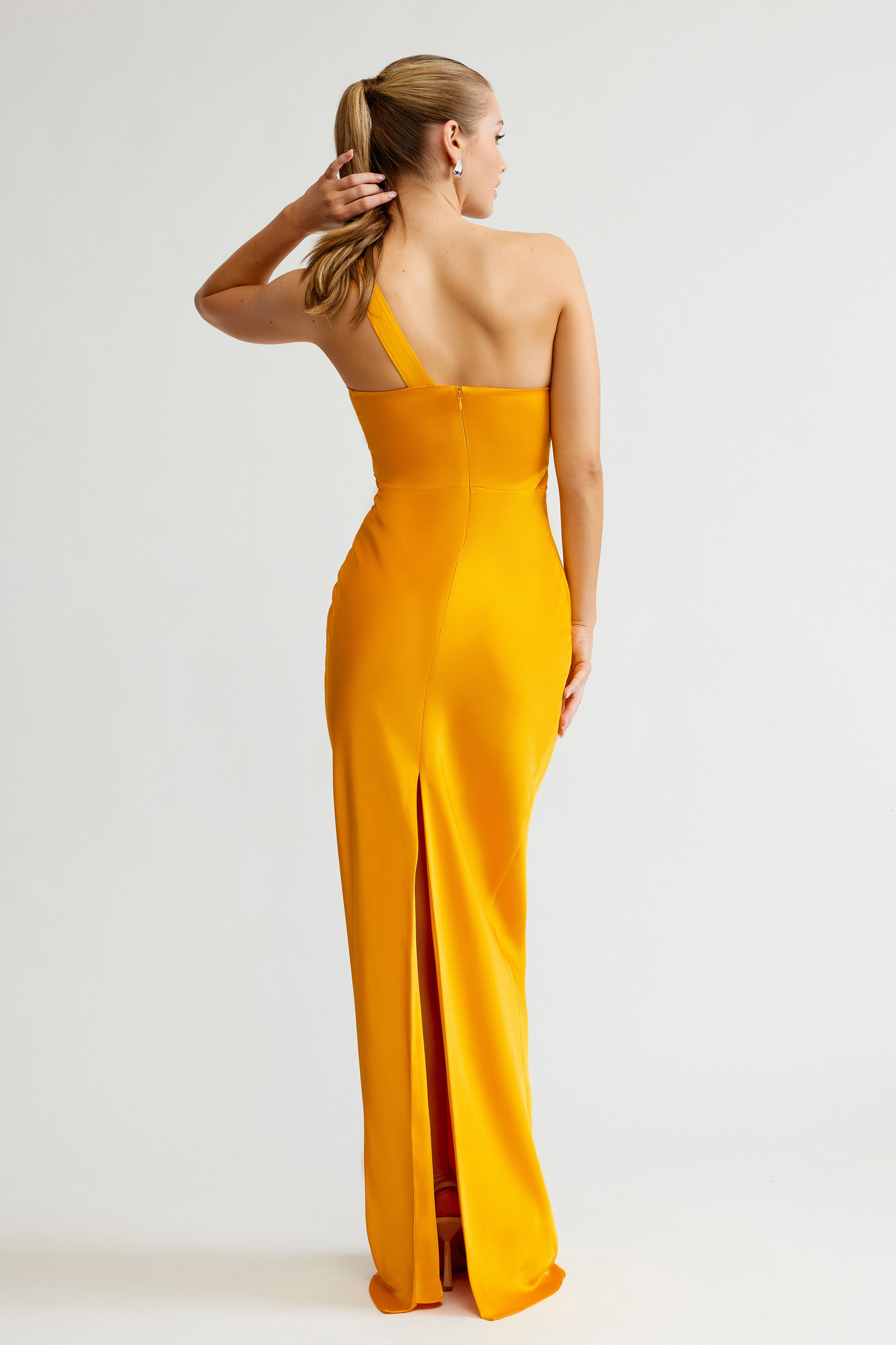 Clarisse Dress featuring a one-shoulder design with a back slit in saffron satin for formal and black tie events