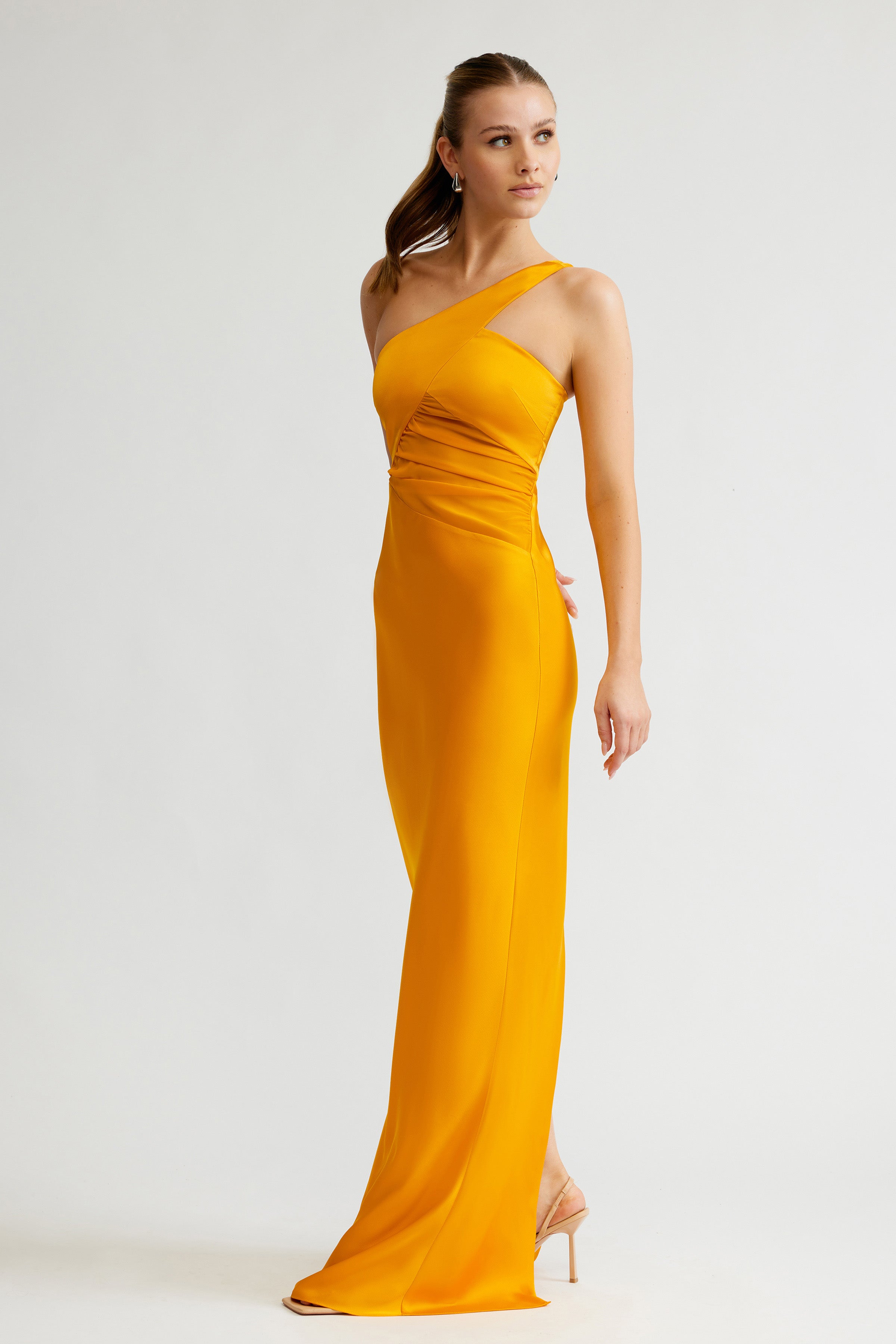 Clarisse Dress featuring a sleek one-shoulder design in saffron satin with ruched detail for formal events