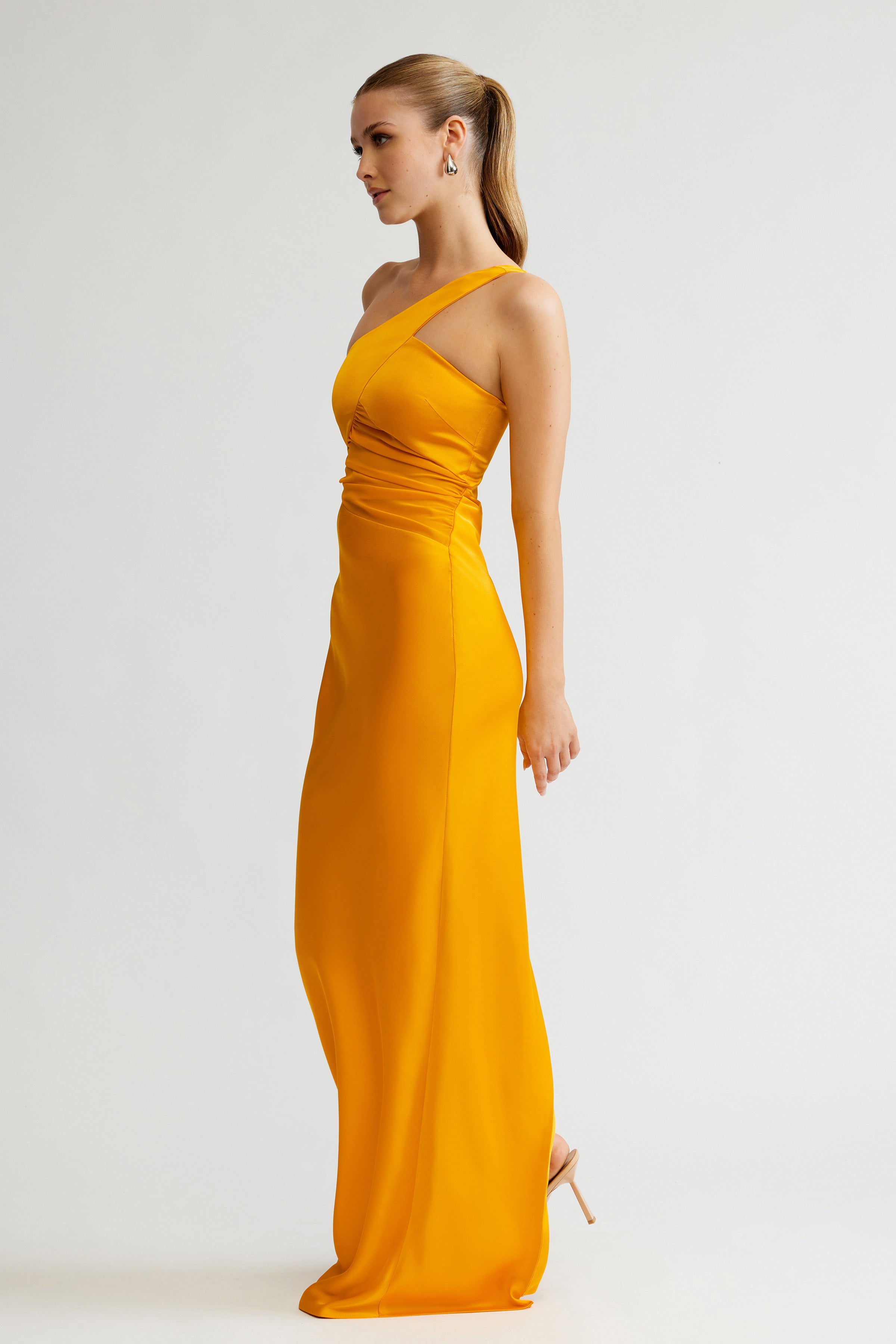 Clarisse Dress featuring a sleek one-shoulder design in saffron satin with ruched waist for formal black tie events