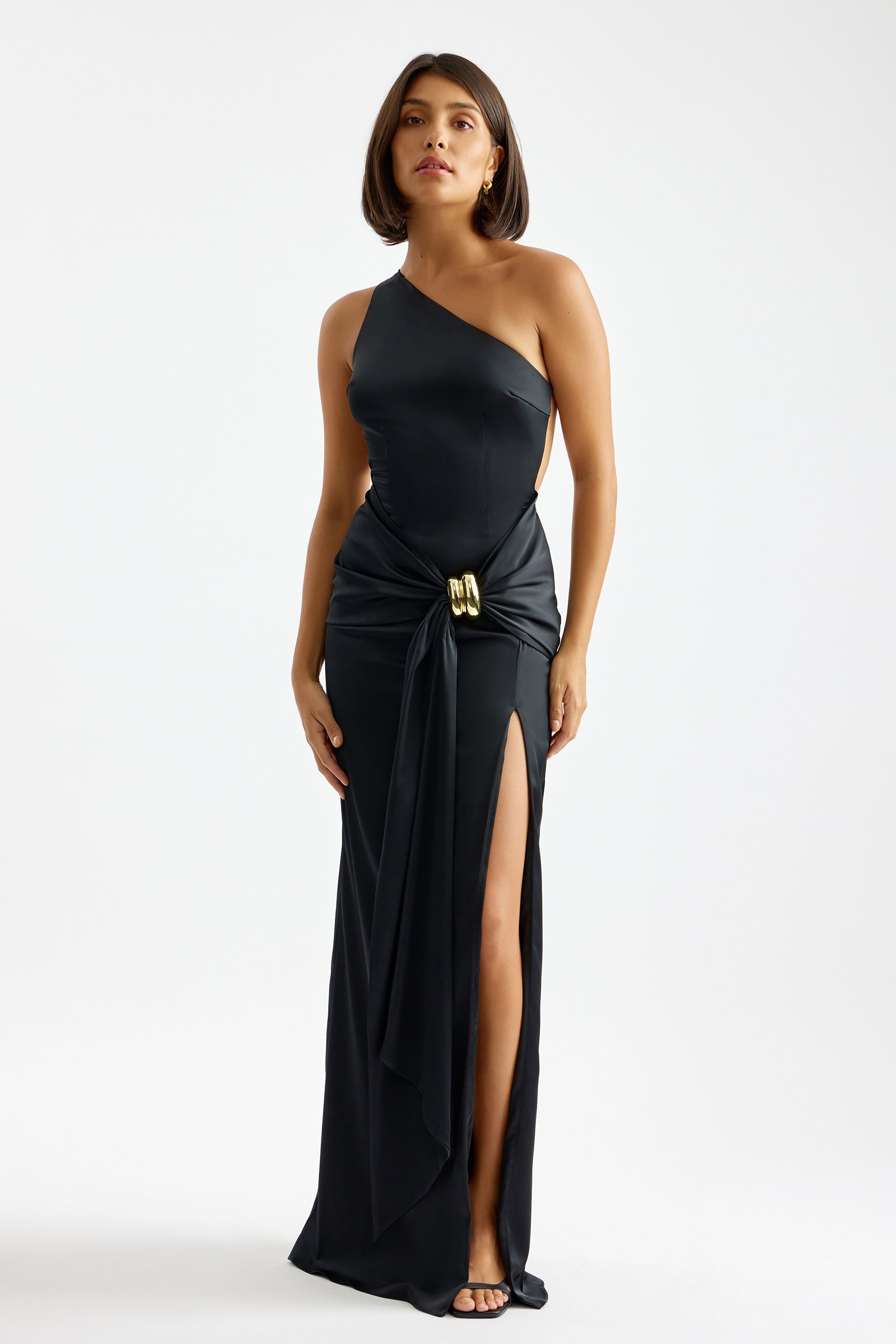 Clea Dress featuring one-shoulder neckline, high side split, and draped waist detail in black for formal occasions