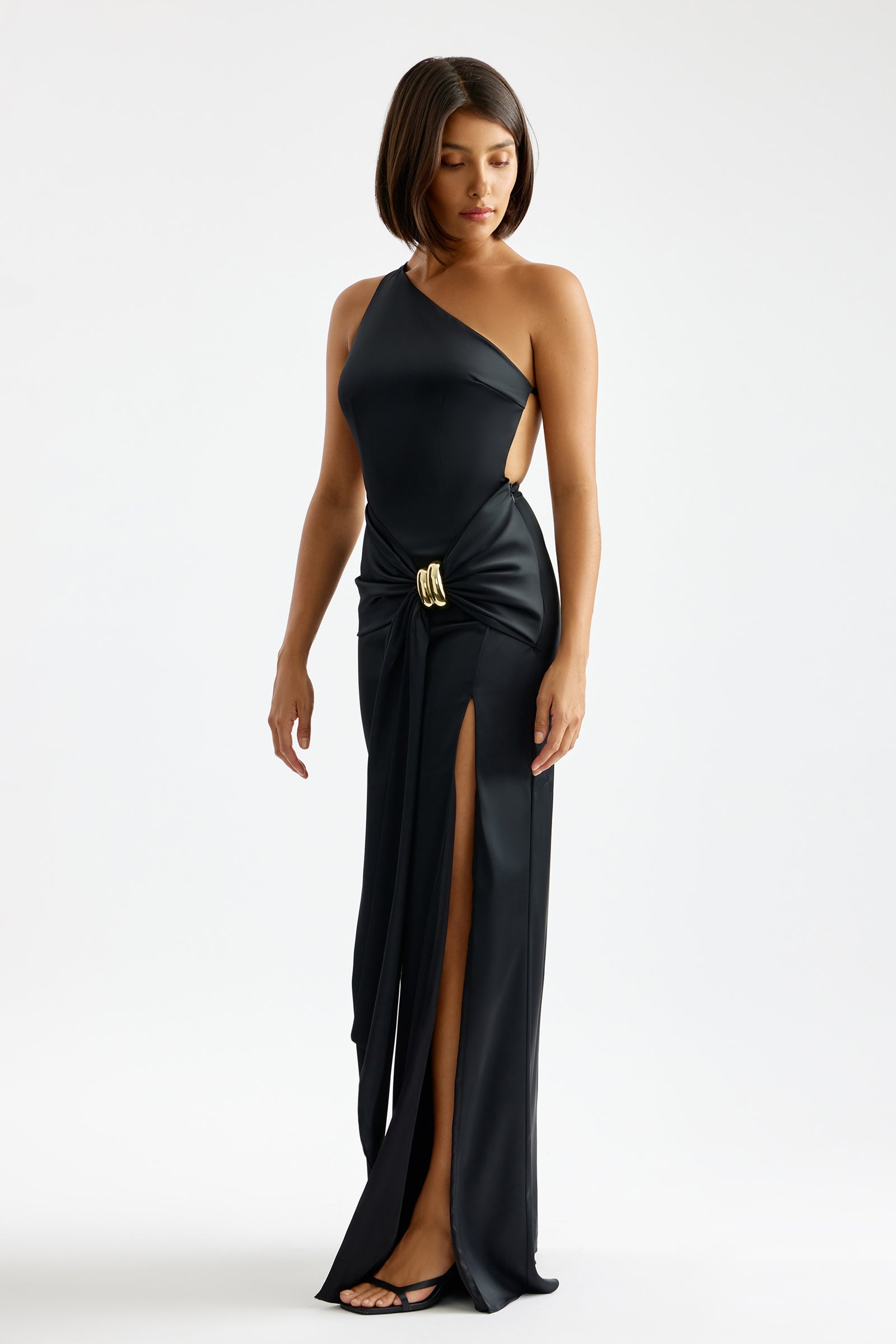 Clea Dress with asymmetric neckline, high side split, and gold buckle detail in black for formal and black tie occasions by Studio Lexi