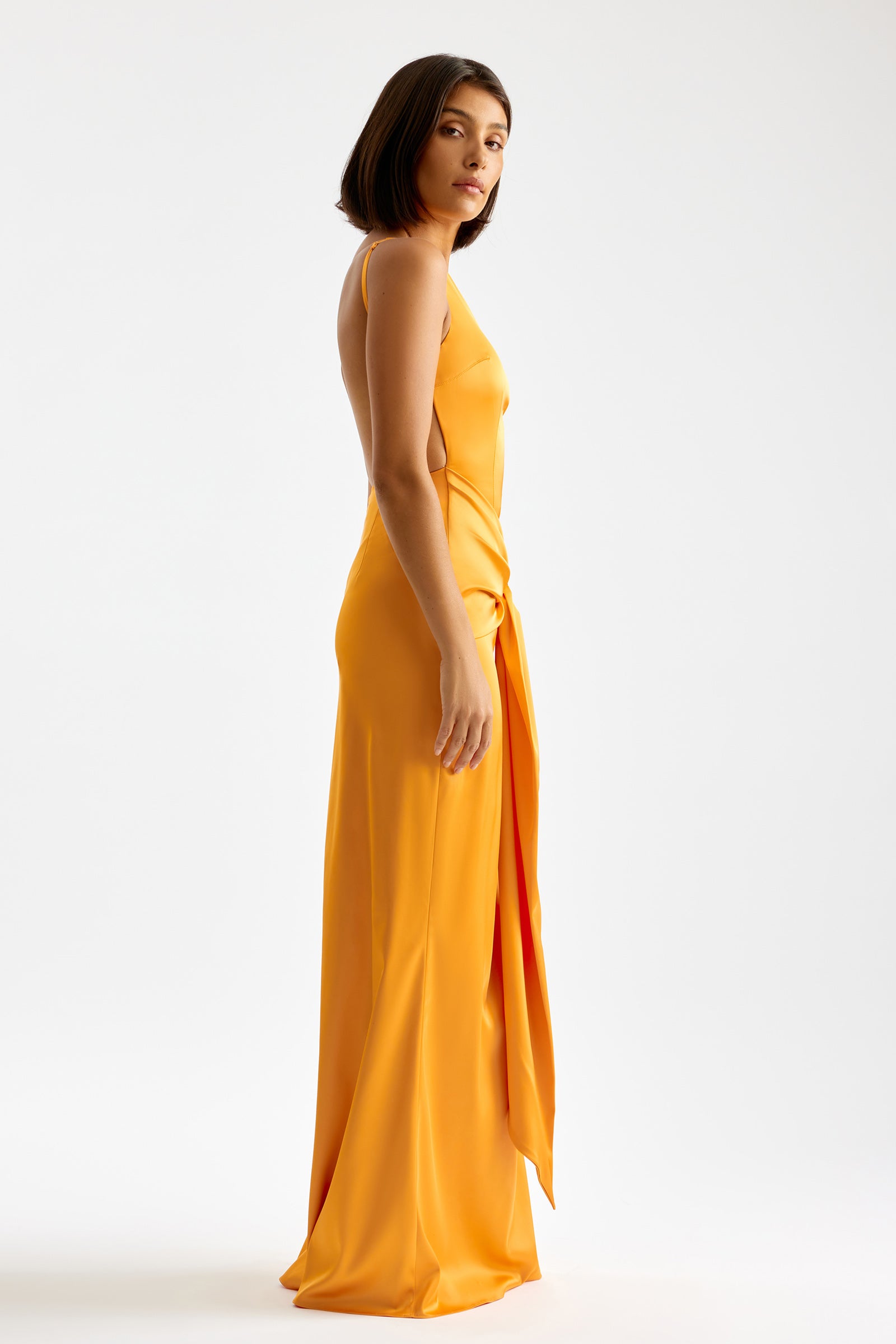 Clea Dress featuring a backless silhouette and high side split in vibrant orange for formal and black tie occasions by Studio Lexi