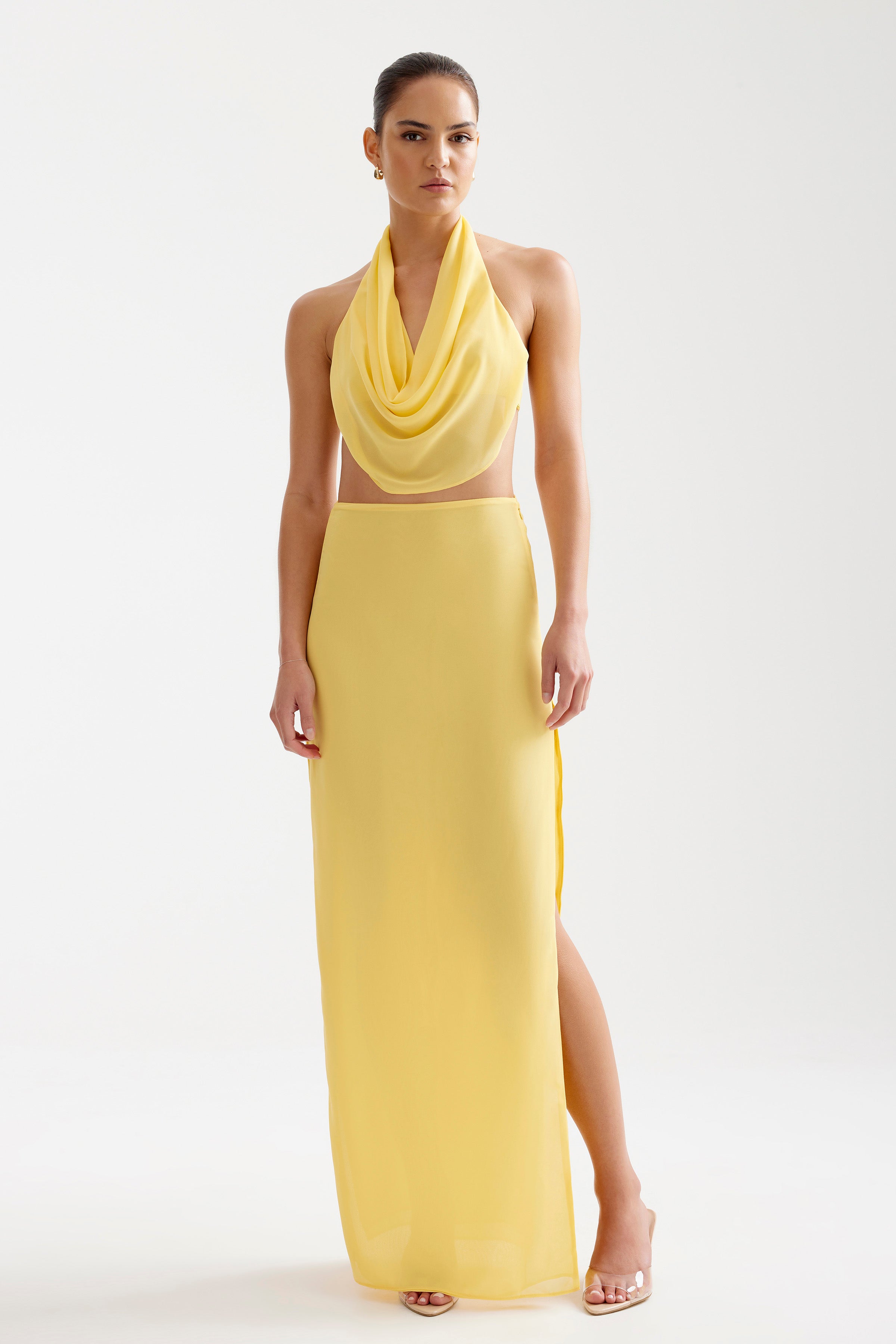 Clio Set featuring a draped halter top and a high-slit long skirt in soft yellow for elegant occasions
