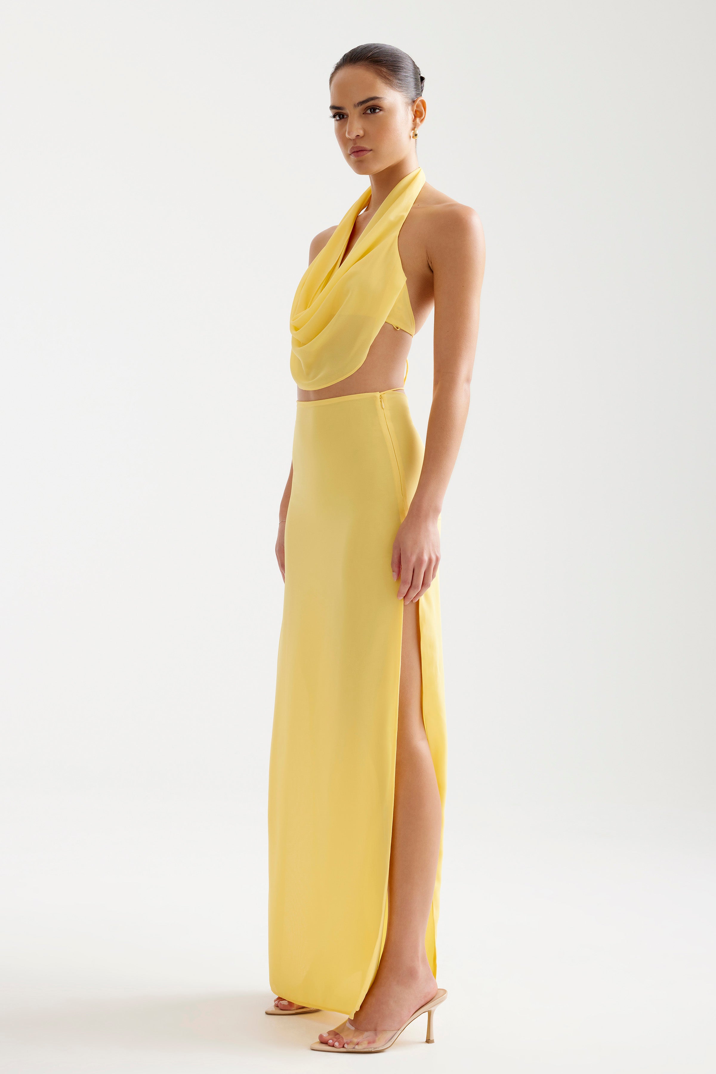 Clio Set featuring a backless halter top with draped neckline and a high-slit long skirt in vibrant yellow