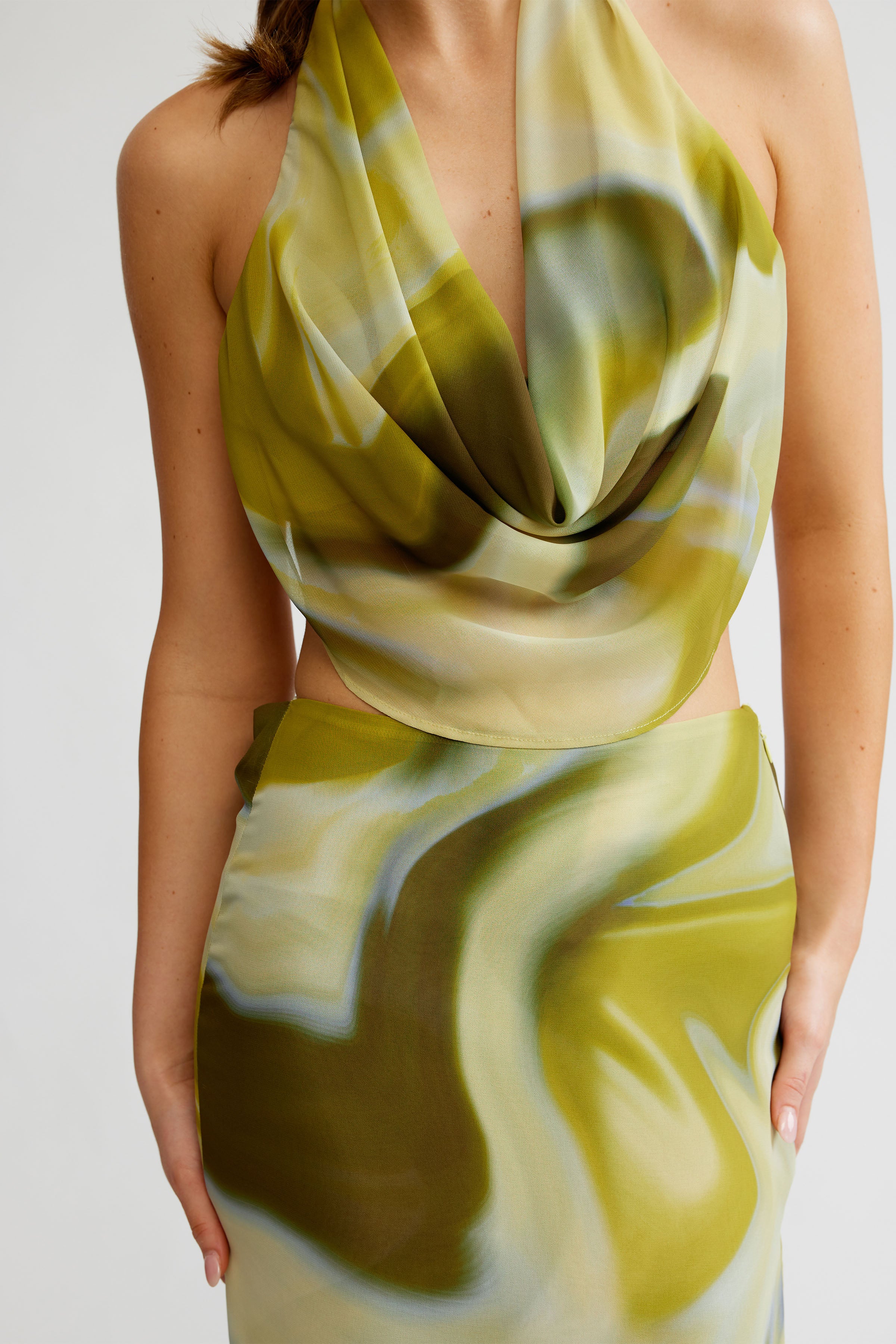Clio Set featuring a draped halter top and matching skirt with fluid print in green tones for formal occasions