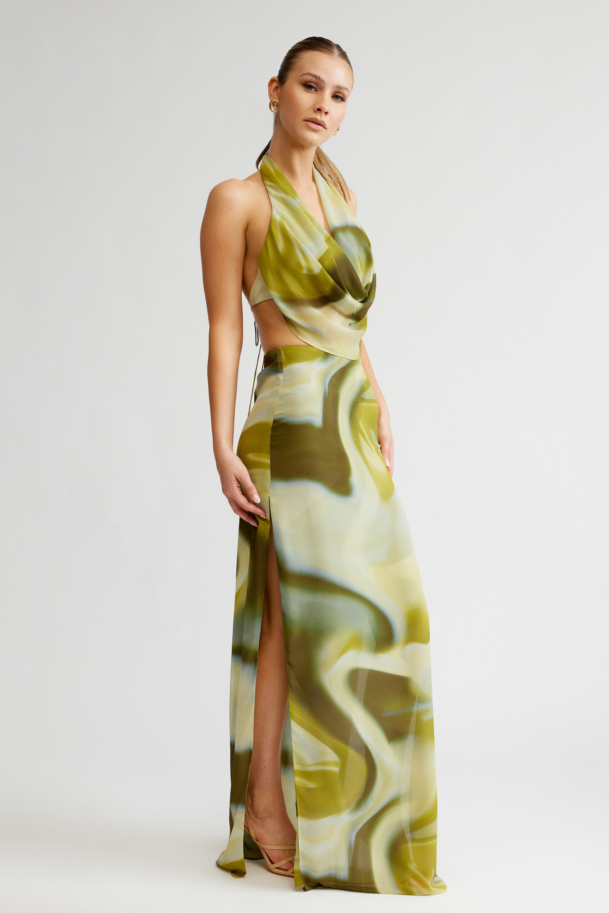 Clio Set featuring a backless halter top and high split flowing skirt in green and cream print for formal occasions