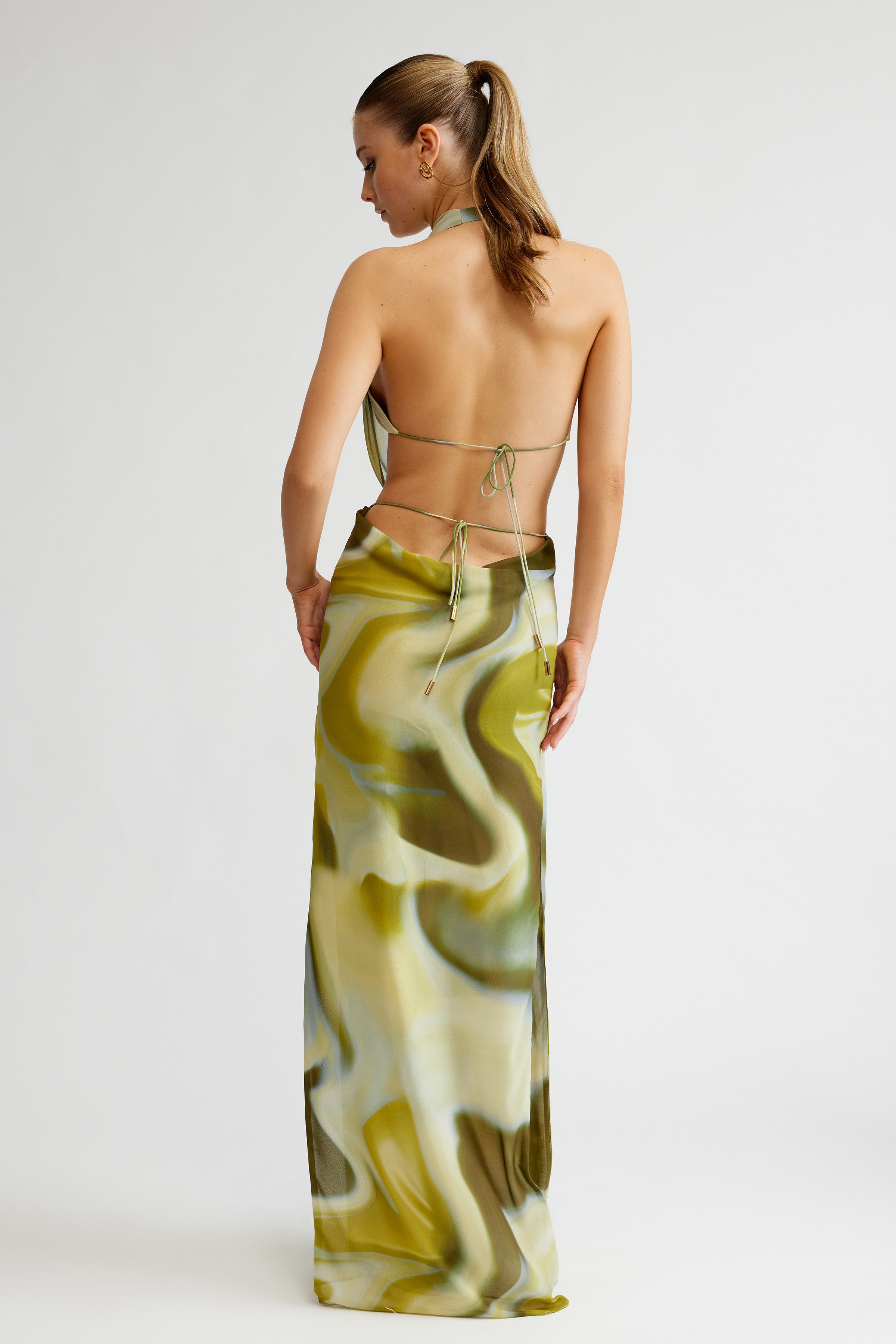 Clio Set featuring a backless halter top and flowing printed skirt in green tones for formal and cocktail occasions