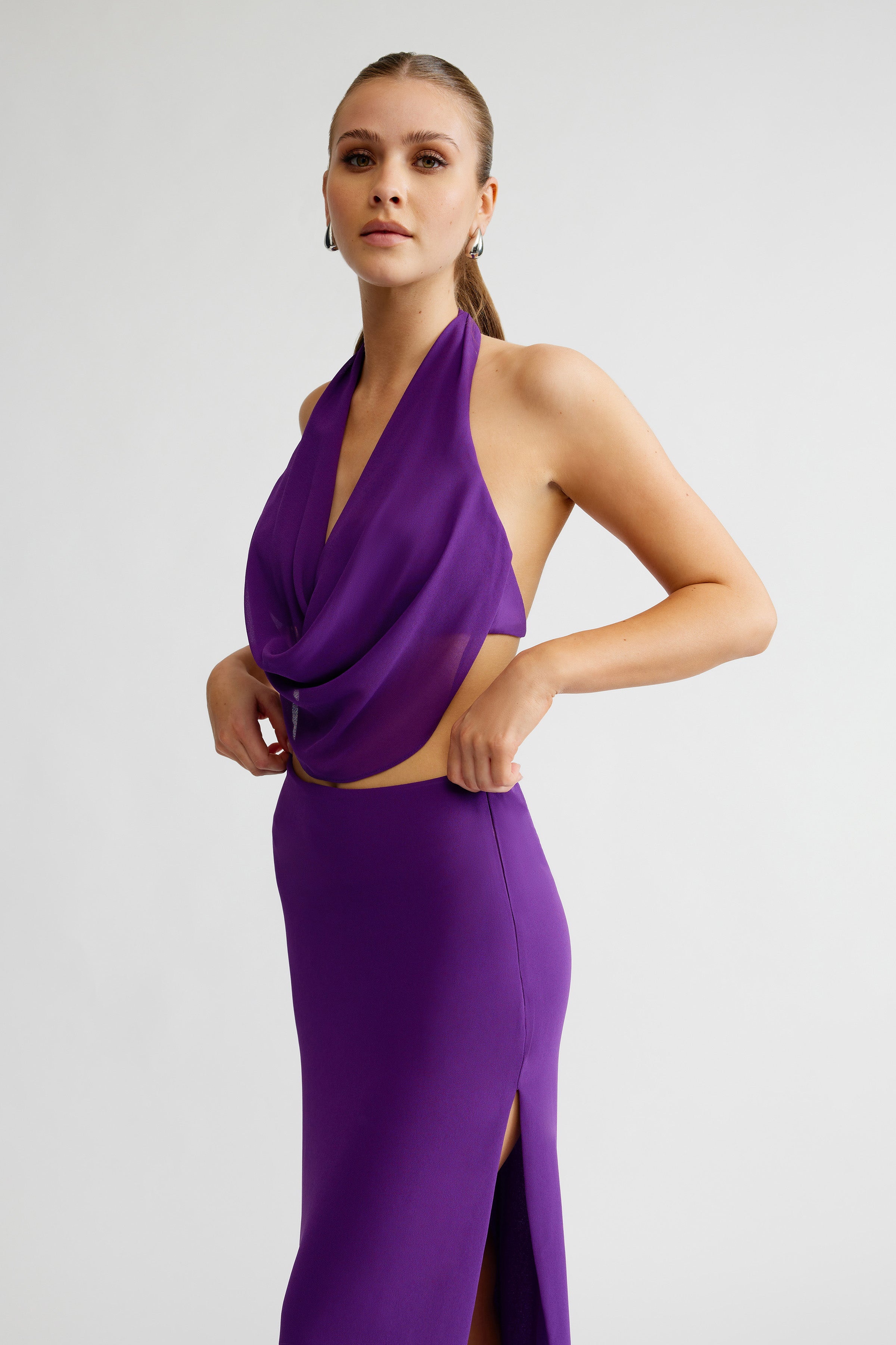 Clio Set featuring a draped halter top and high slit fitted skirt in vibrant violet for elegant occasion wear