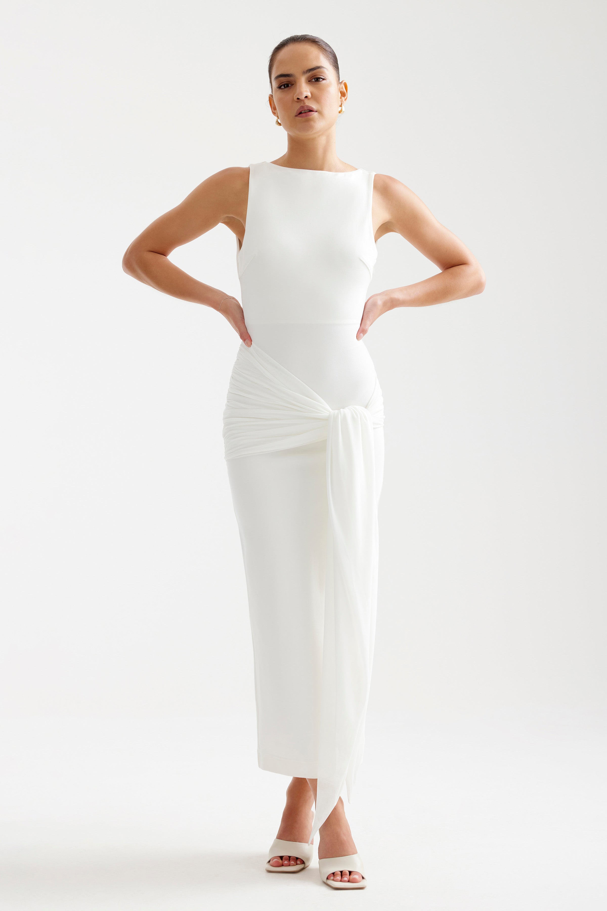 Elara Dress featuring a sleek sleeveless design with ruched draped tie detail in ivory by Studio Lexi