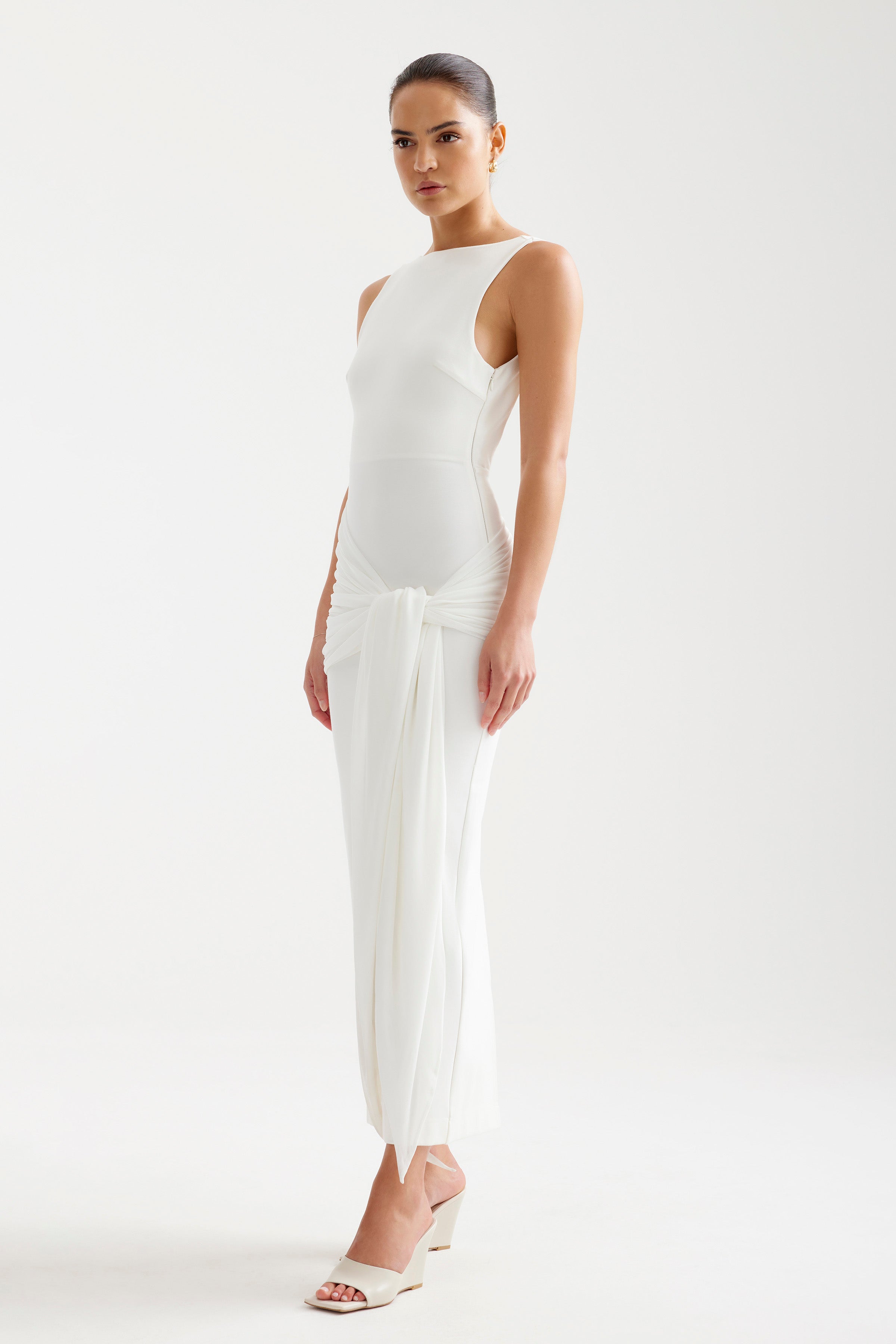 Elara Dress featuring a sleek sleeveless silhouette with ruched knotted detailing in elegant ivory by Studio Lexi