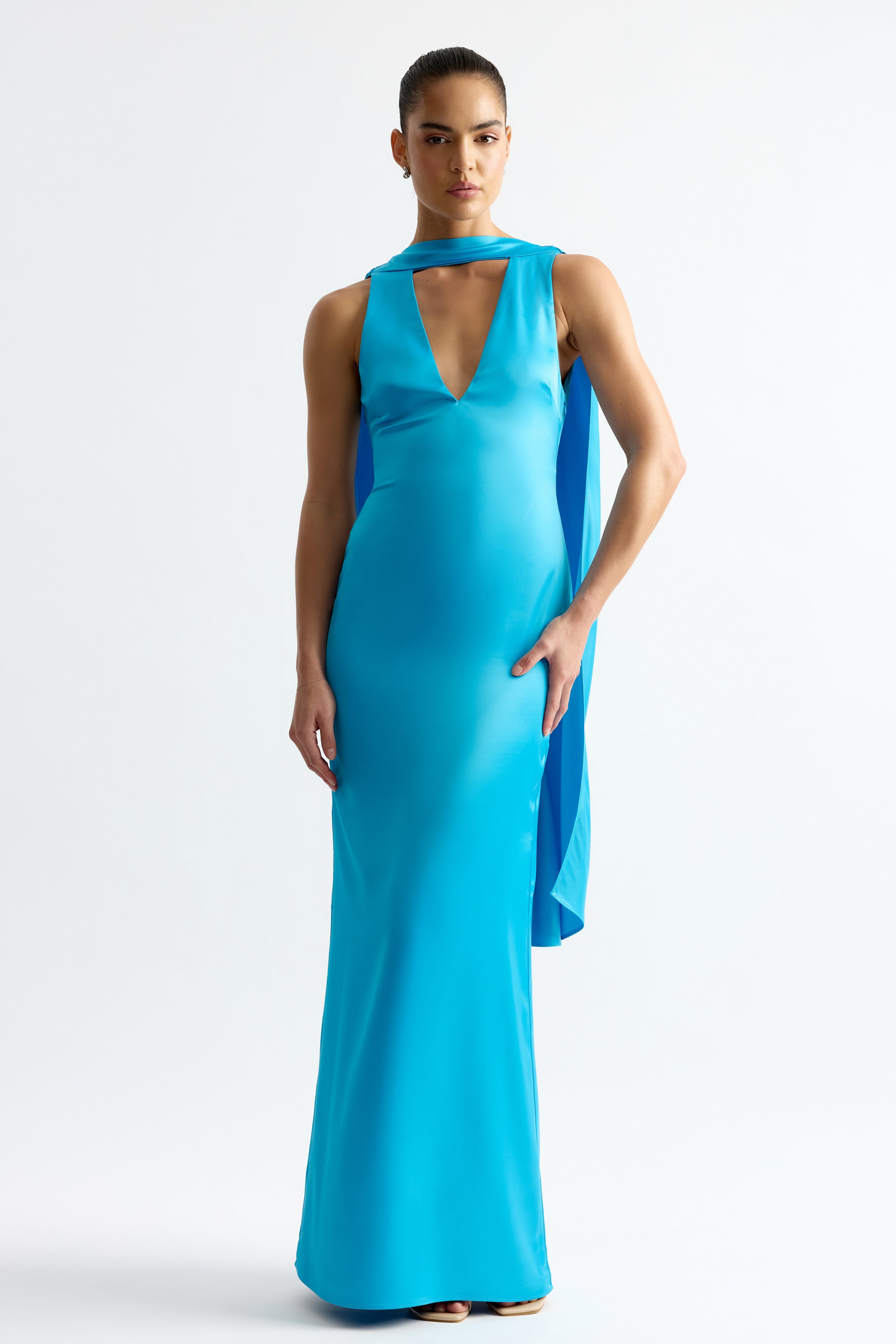 Eloise Dress featuring a sleek silhouette with plunging neckline and flowing cape detail in capri blue by Studio Lexi