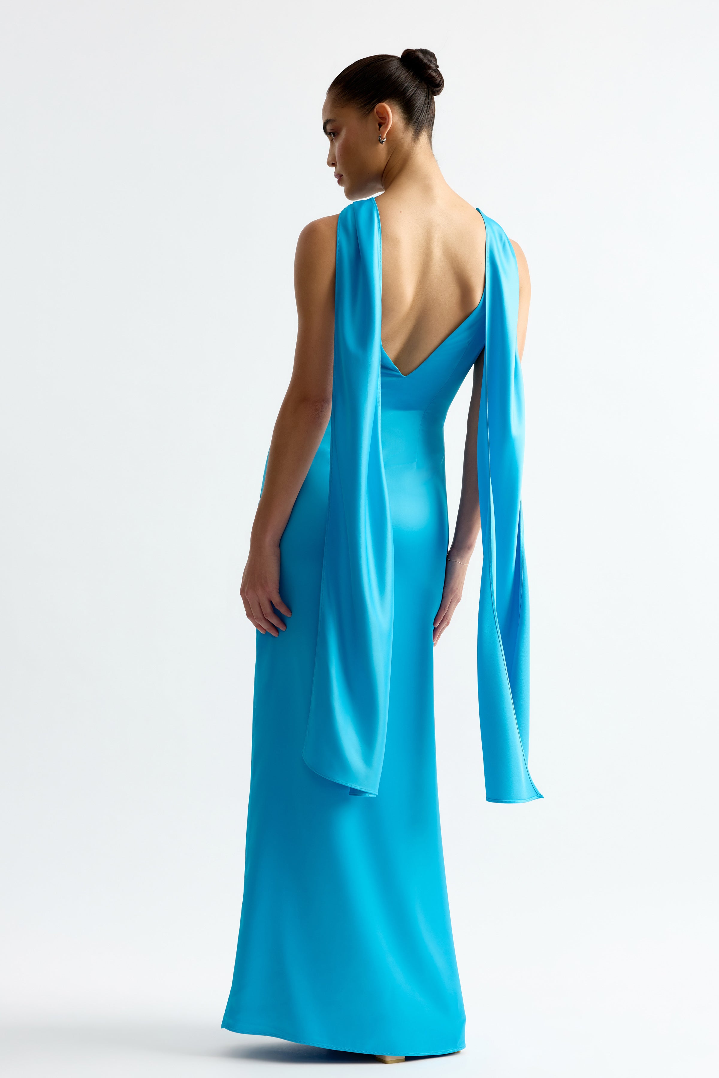 Eloise Dress featuring a deep V-back and flowing shoulder drapes in vibrant Capri blue by Studio Lexi