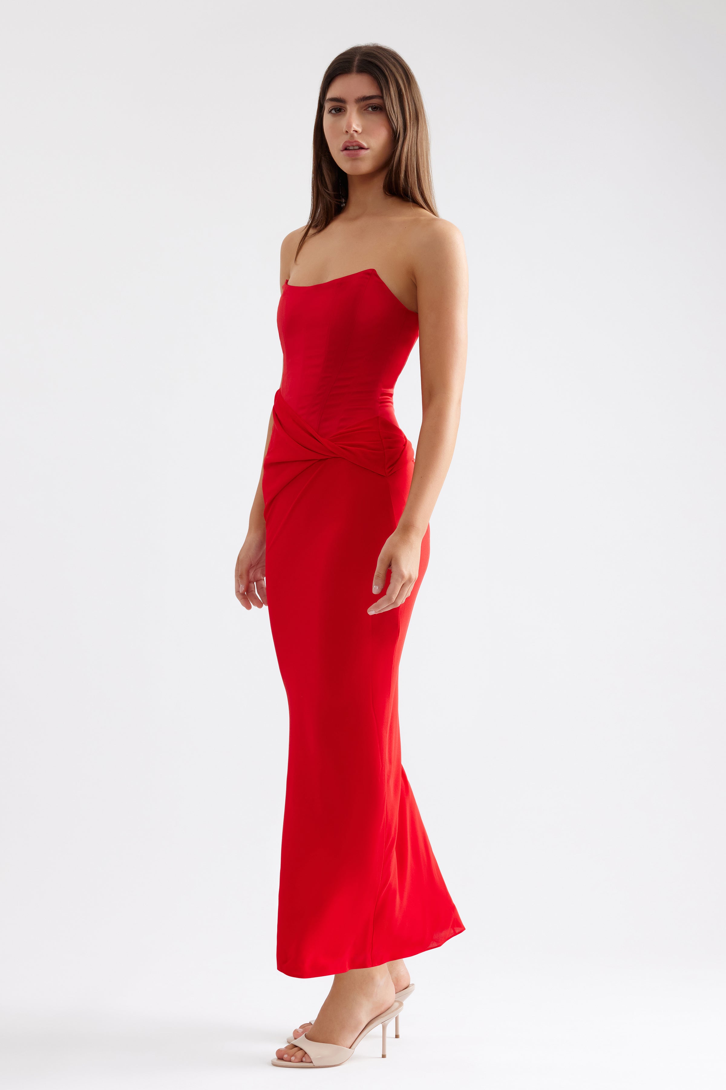 Elora Dress features a sleek strapless silhouette with a ruched detail in vibrant scarlet for formal and black tie events