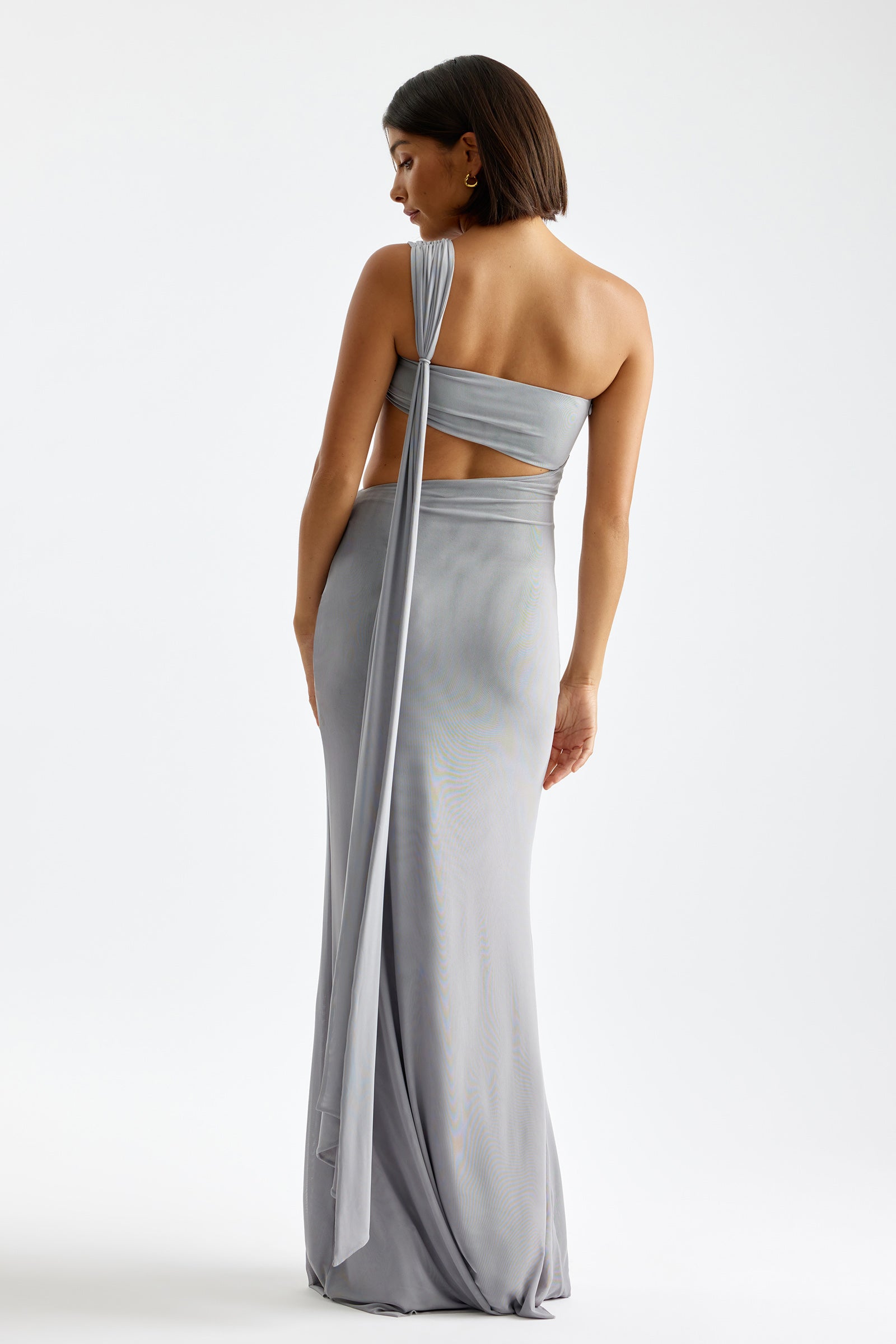 Emery Dress with one-shoulder design, back cutout, and long drape detail in light grey for formal and black tie occasions by Studio Lexi