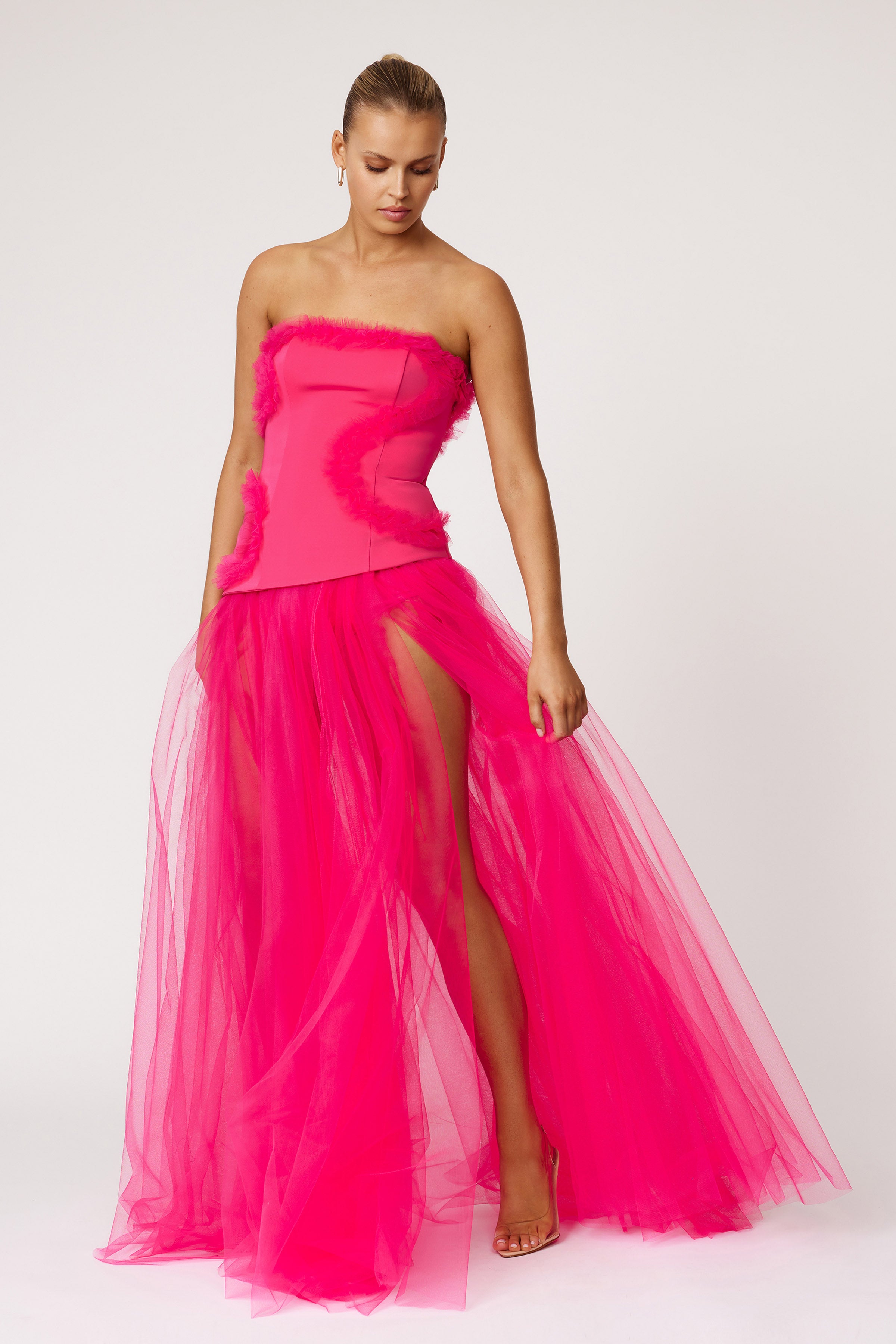 Emilie Dress strapless design with fitted bodice and flowing sheer skirt featuring high splits in vibrant raspberry by Studio Lexi