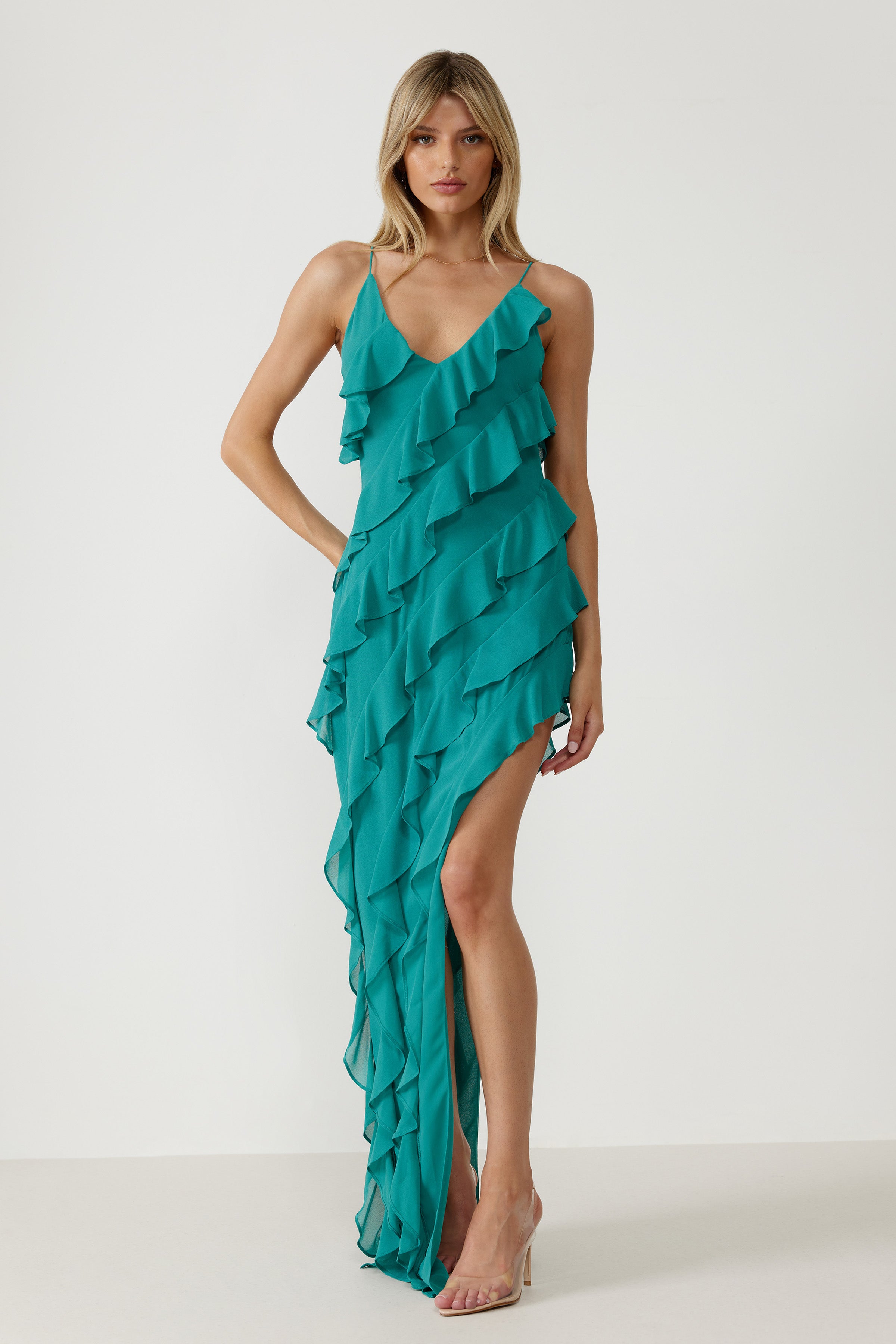Etienne Dress featuring flowing layered ruffles, delicate straps, and a high slit in vibrant teal for formal occasions