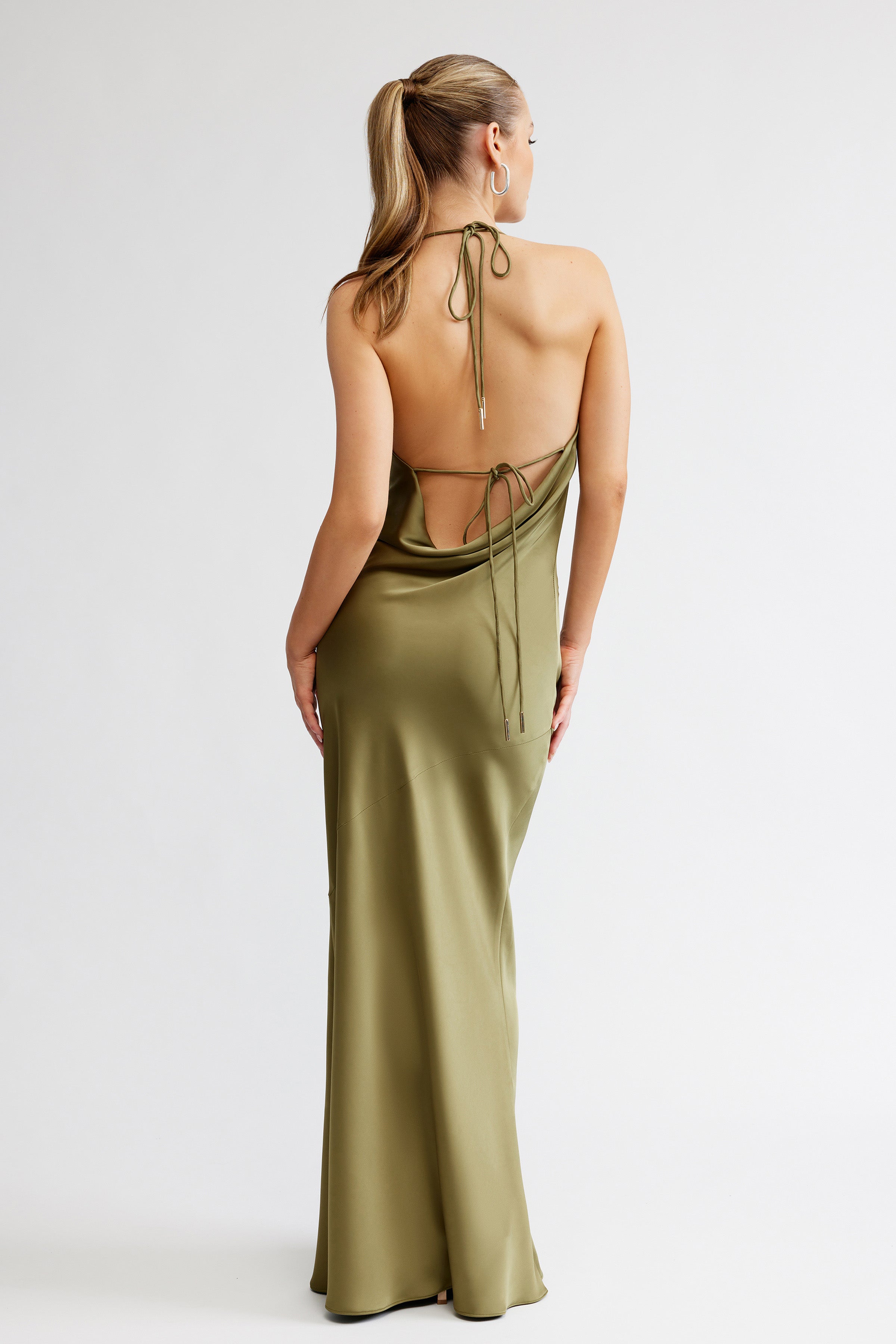 Freya Dress featuring a backless, tie-back design with a sleek draped silhouette in olive satin for formal occasions