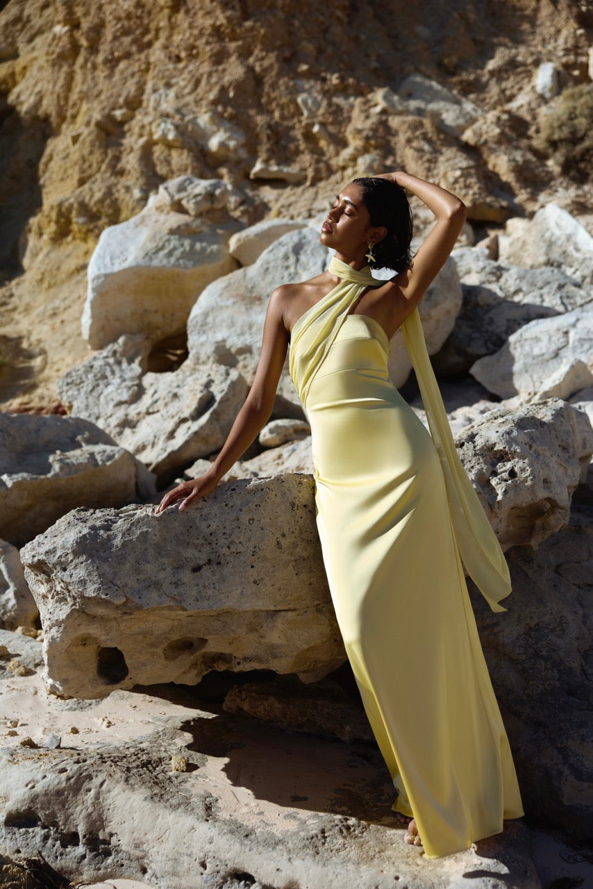 Hali Dress featuring a sleek halter neckline and flowing design in sunflower yellow by Studio Lexi for formal occasions