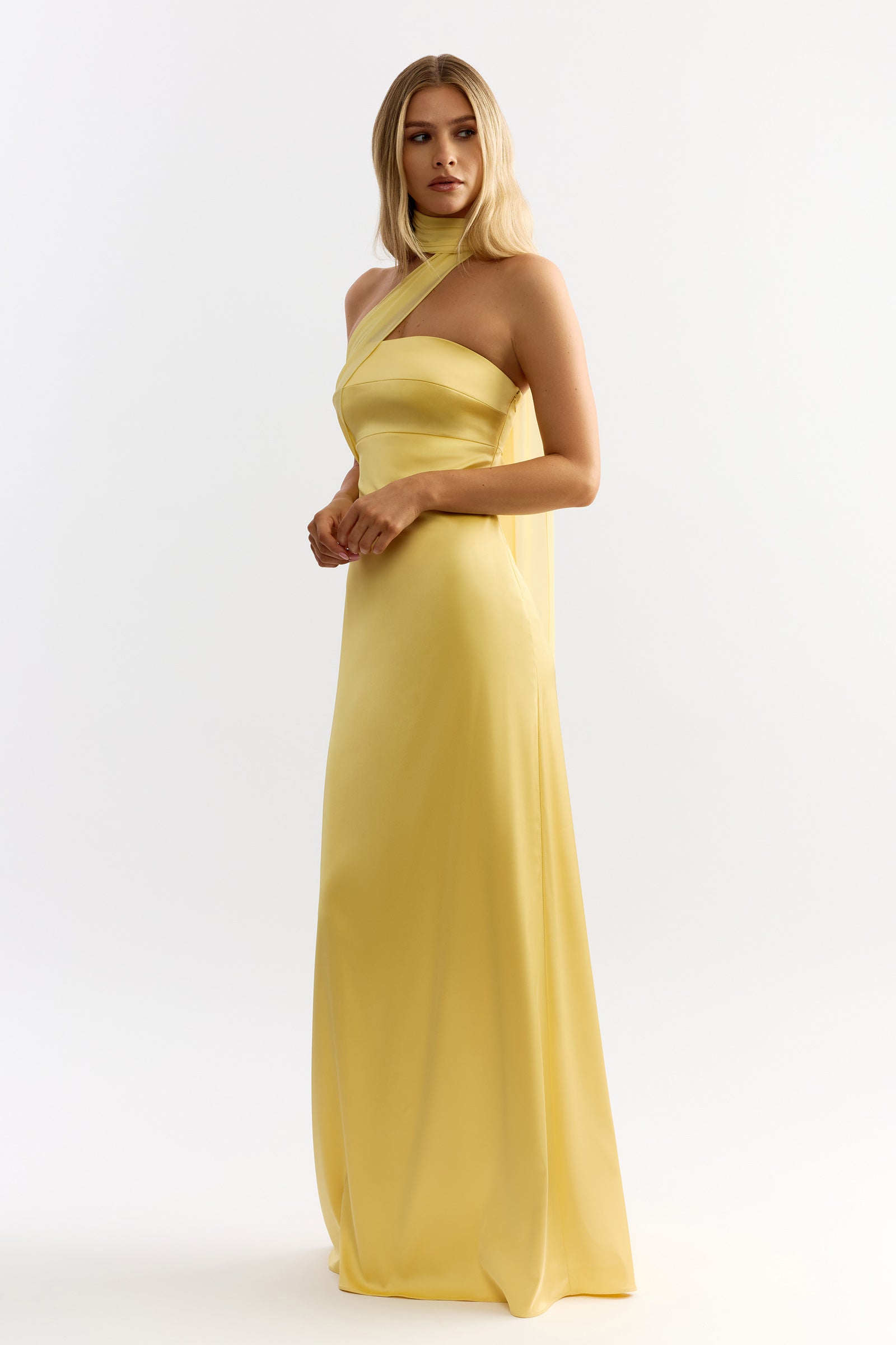 Hali Dress featuring a strapless silhouette with a single halter wrap and sleek long skirt in sunflower yellow by Studio Lexi