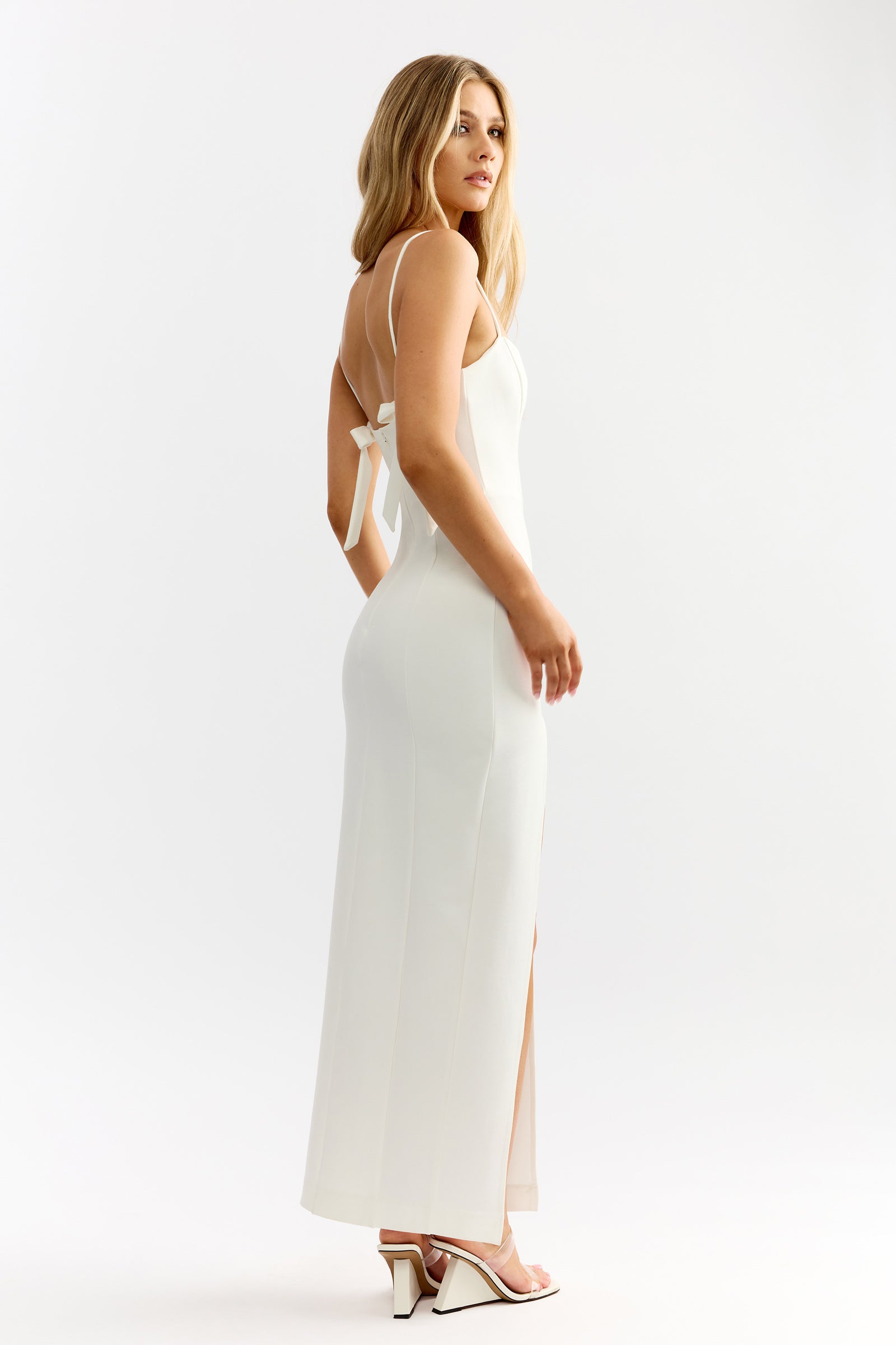 Jenna Dress featuring slender straps and elegant back bow with a sleek fitted silhouette in ivory by Studio Lexi
