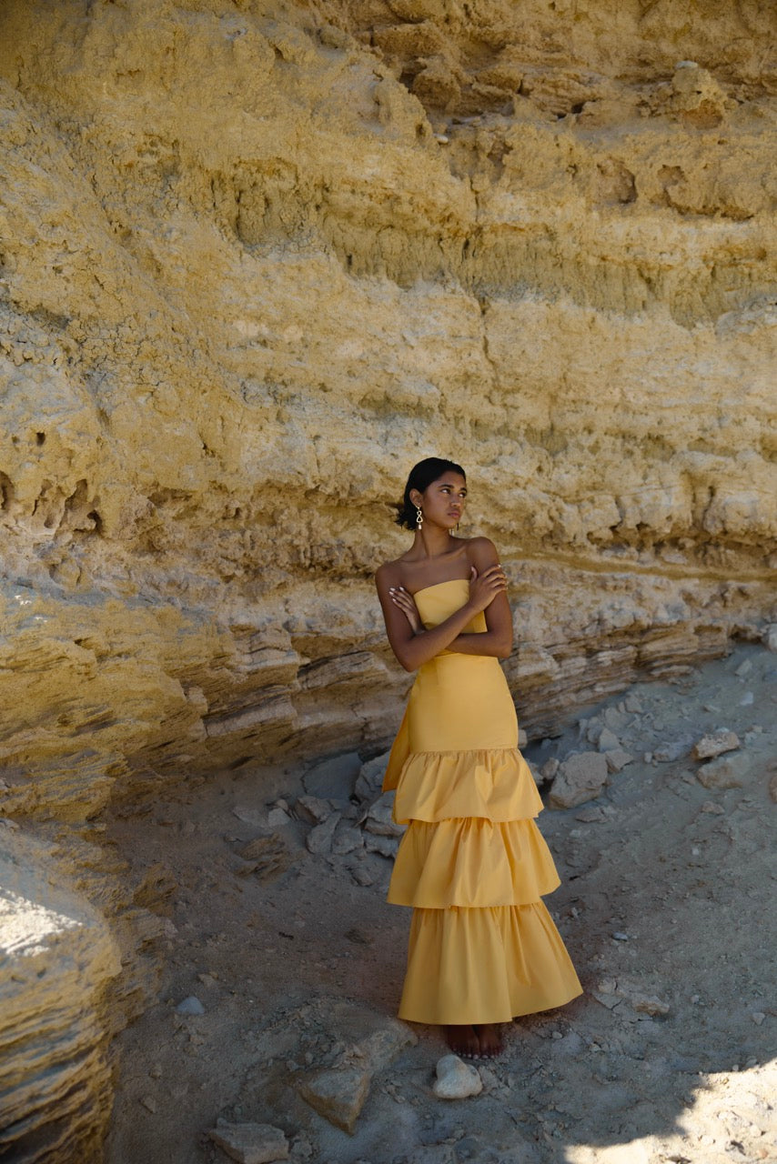 Katy Dress featuring strapless backless design with tiered skirt in warm honey yellow by Studio Lexi