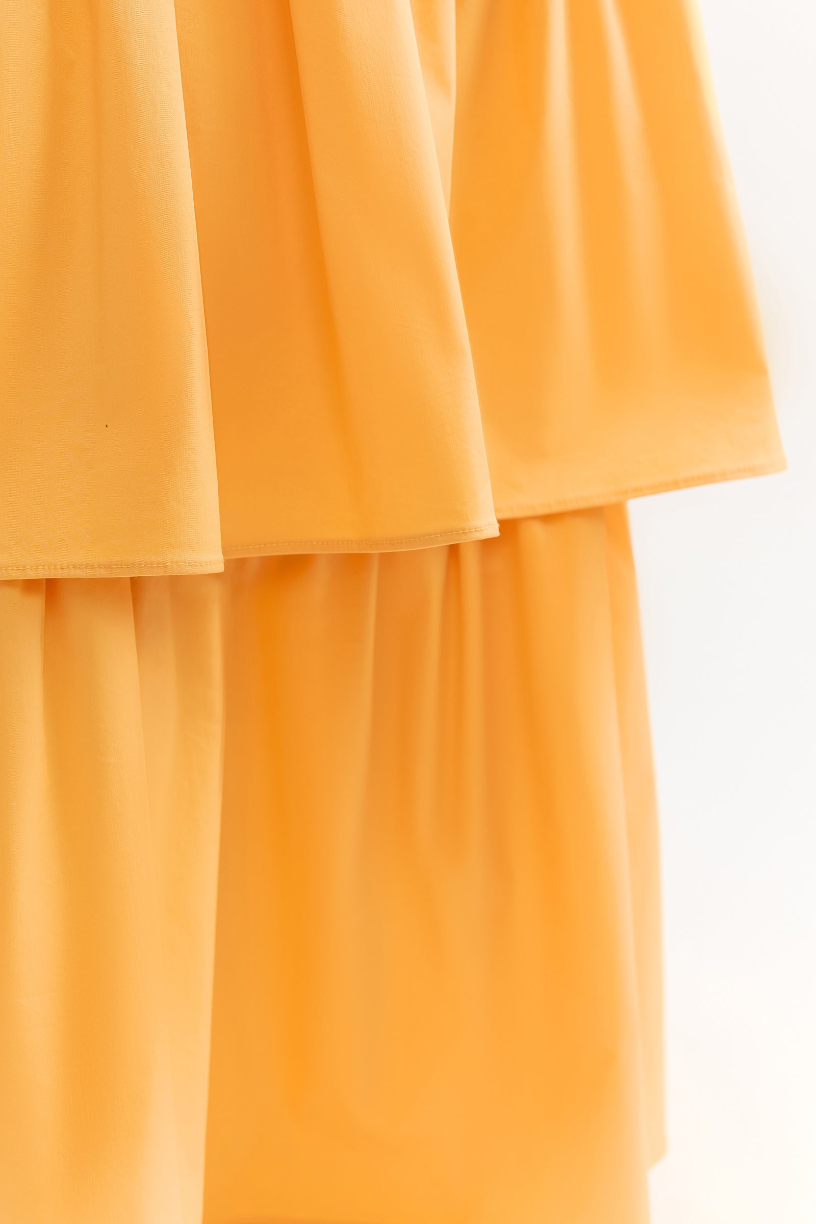 Katy Dress featuring a tiered skirt design in warm honey yellow with backless silhouette by Studio Lexi