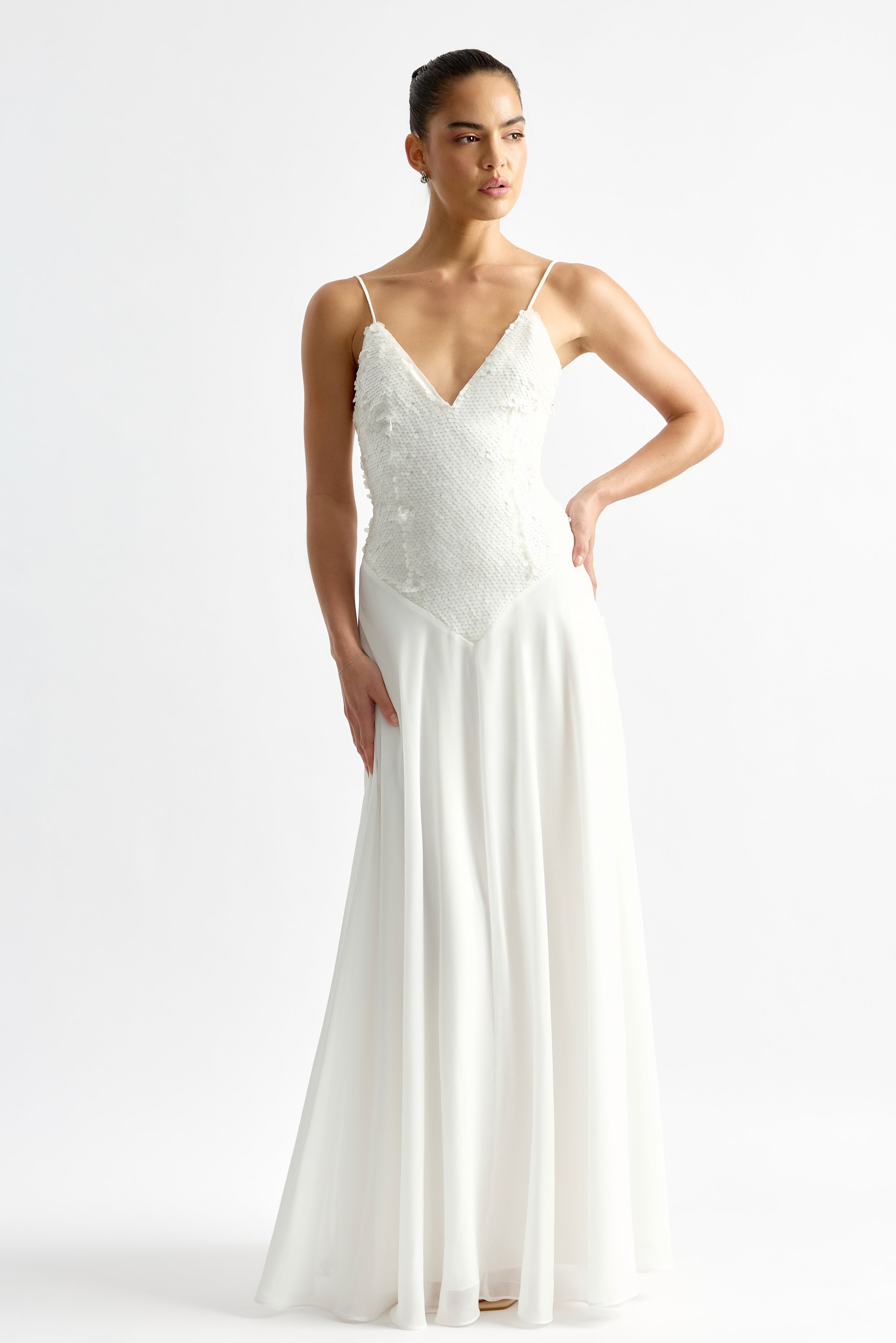 Leandre Dress featuring a beaded bodice with thin straps and flowing skirt in ivory by Studio Lexi