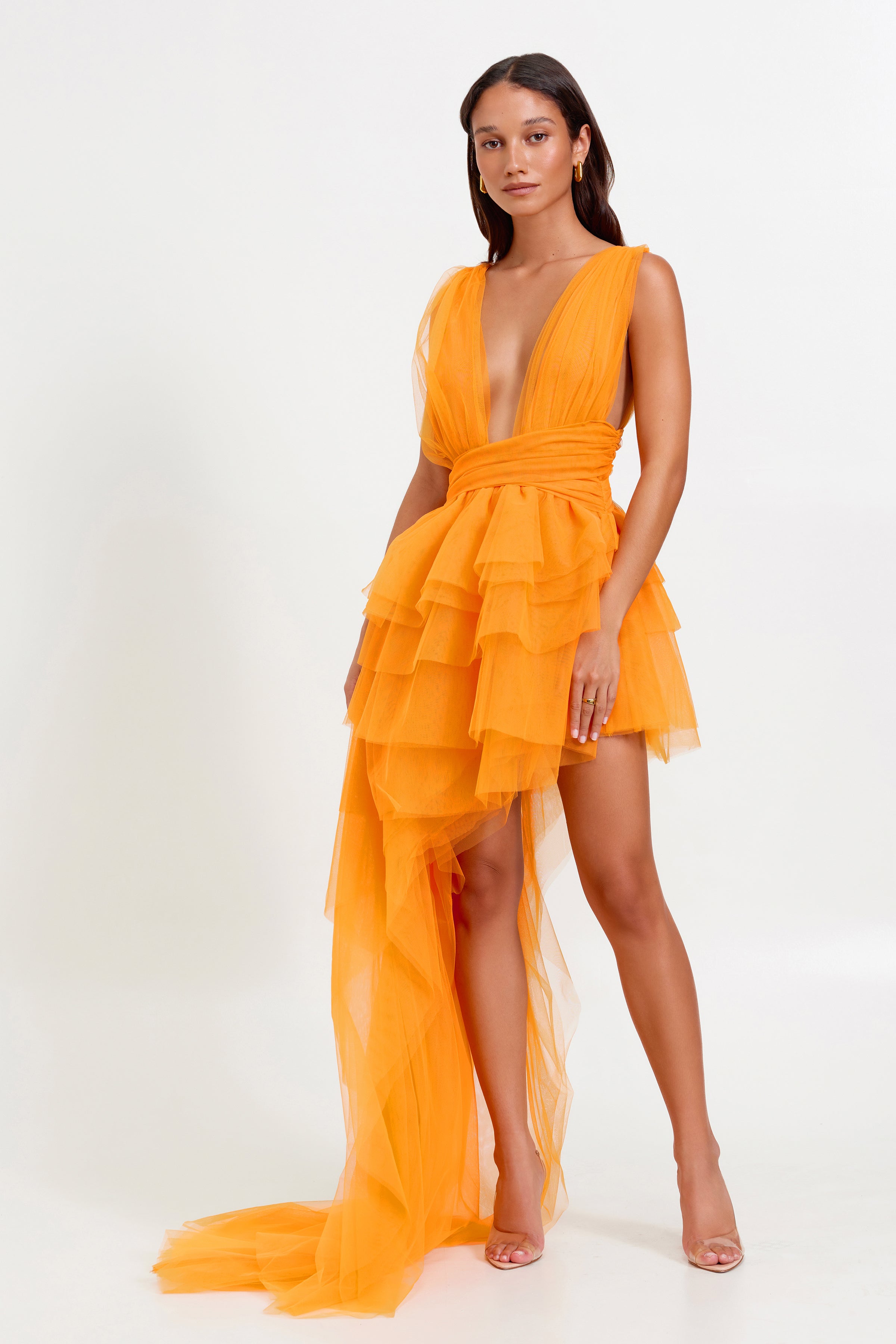 Lola Dress featuring a plunging neckline and layered tulle skirt with a flowing small train in mango for party wear