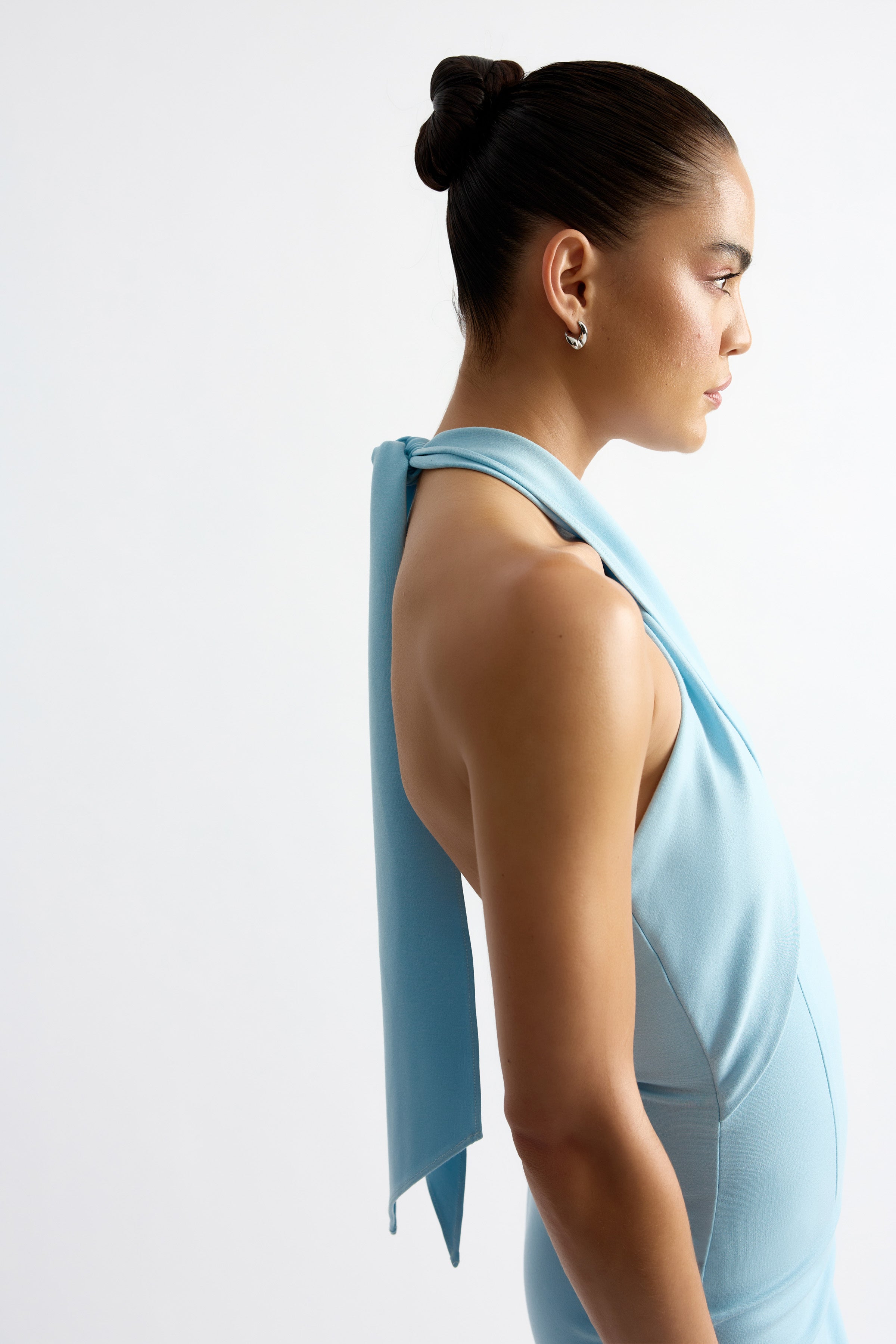 Mathieu Dress featuring a backless halter design in soft blue, crafted for sophisticated occasion wear by Studio Lexi