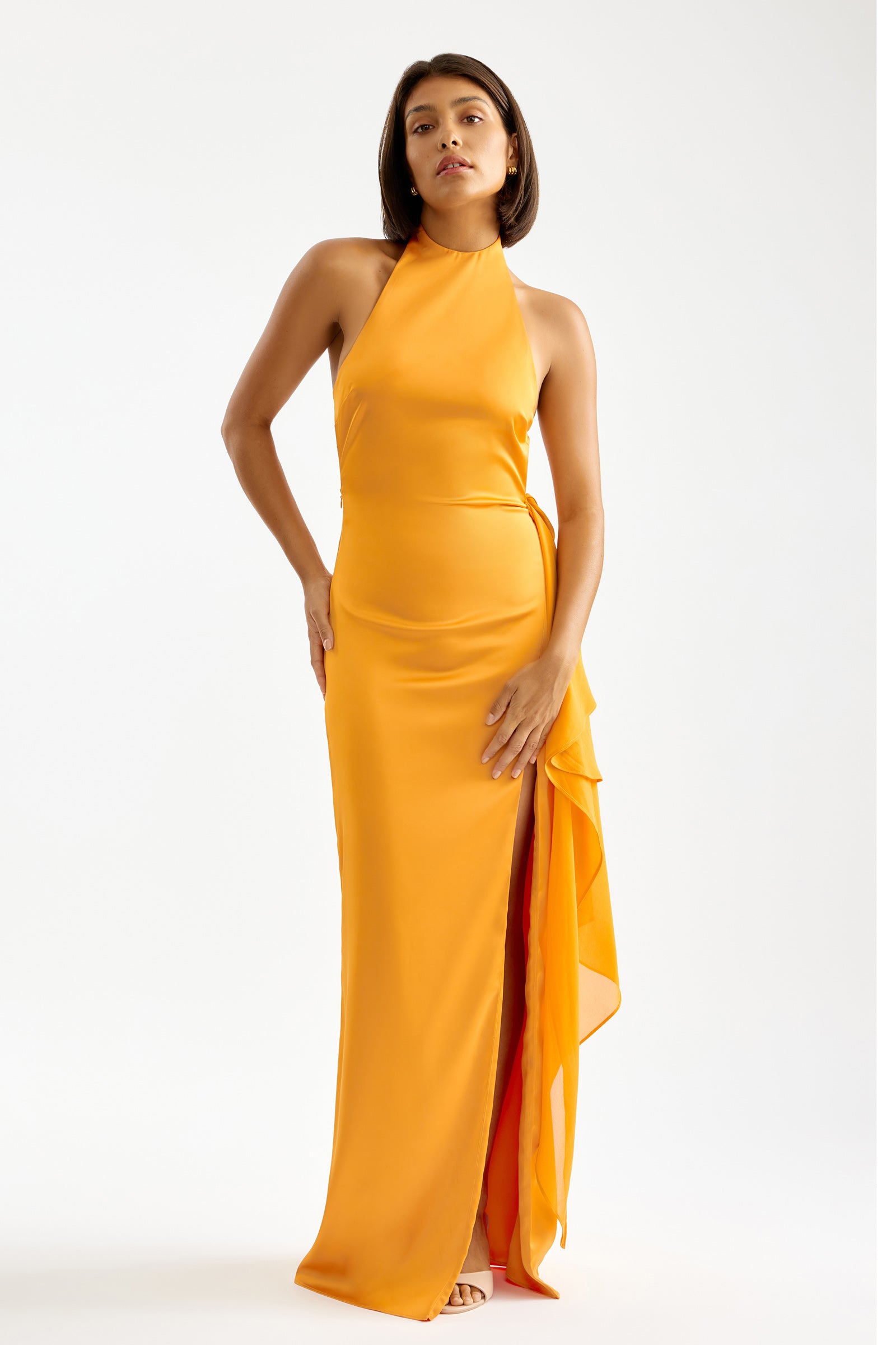 Mona Dress featuring a halter neckline, side split, and draped detail in vibrant orange for formal occasions by Studio Lexi