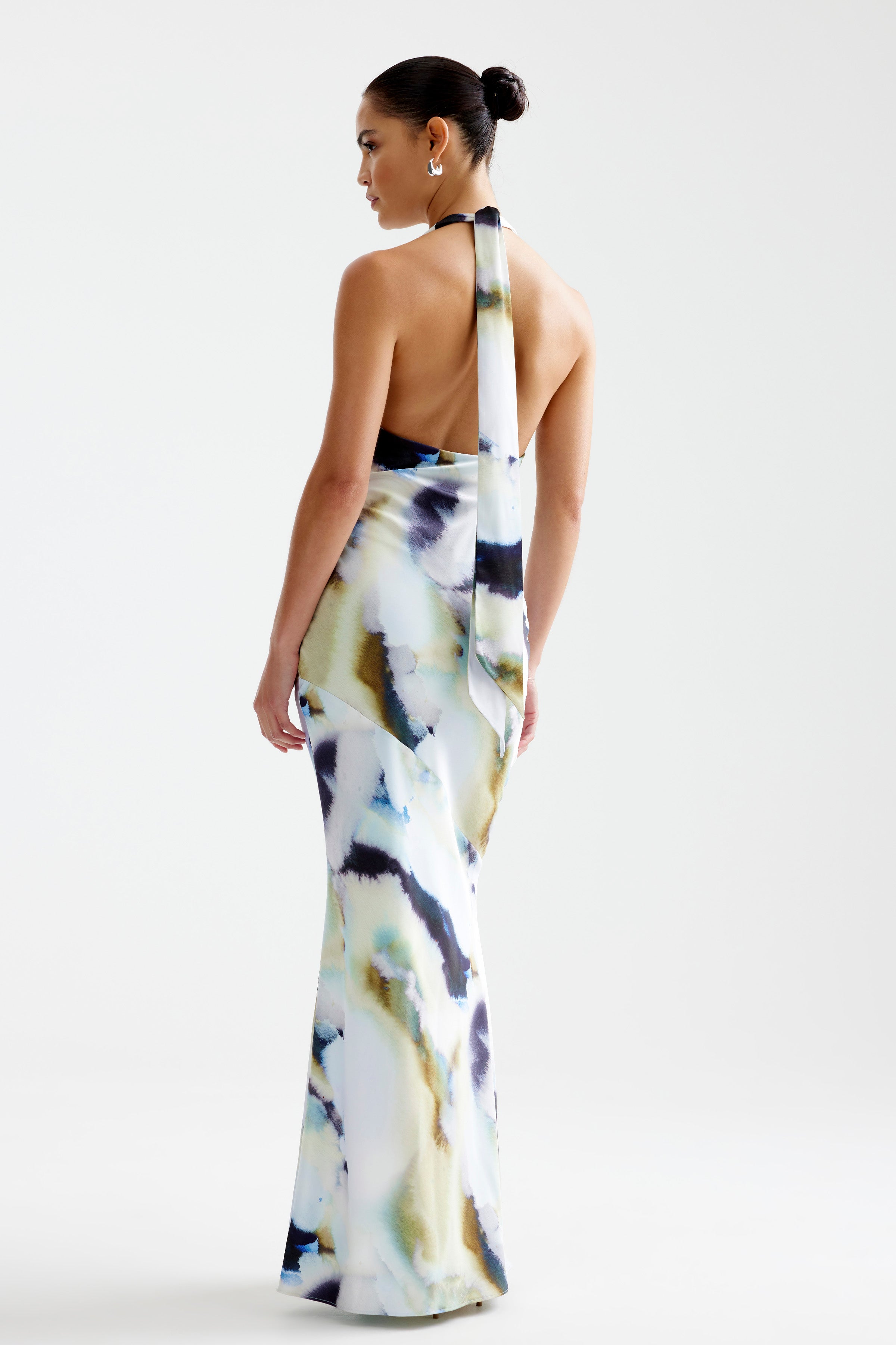 Novia Dress featuring a backless halter design with flowing tie detail in a blue mineral print for formal occasions