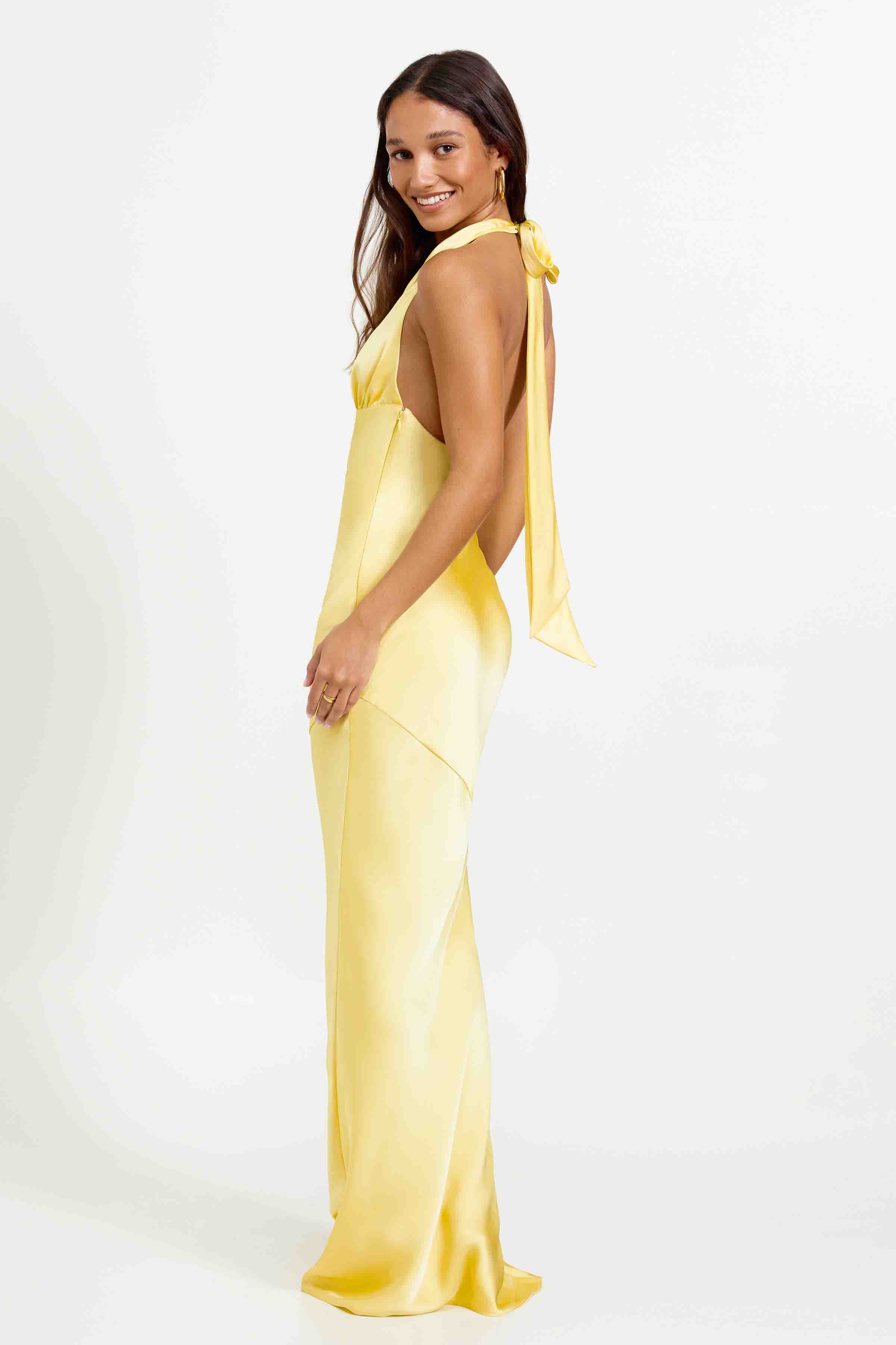 Novia Dress featuring a backless halter neck design in soft pineapple yellow for formal and wedding guest occasions