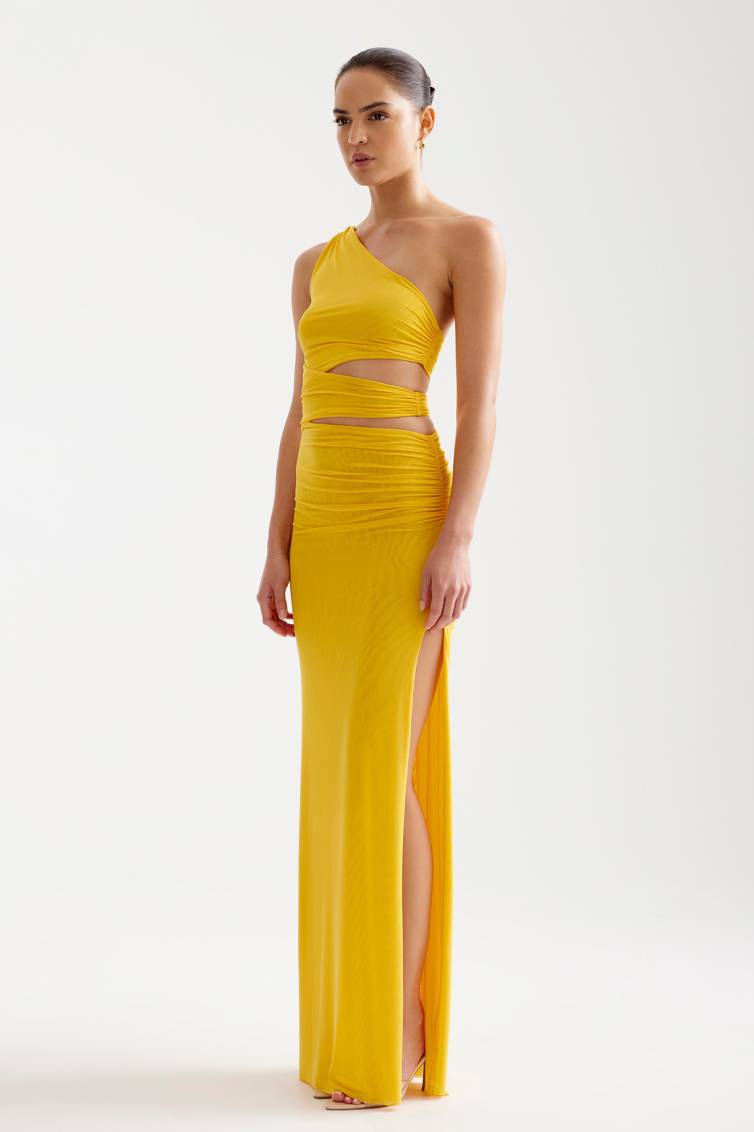 Nuri Dress featuring a one-shoulder cutout design with ruched details and high split in bold burnt orange for formal occasions