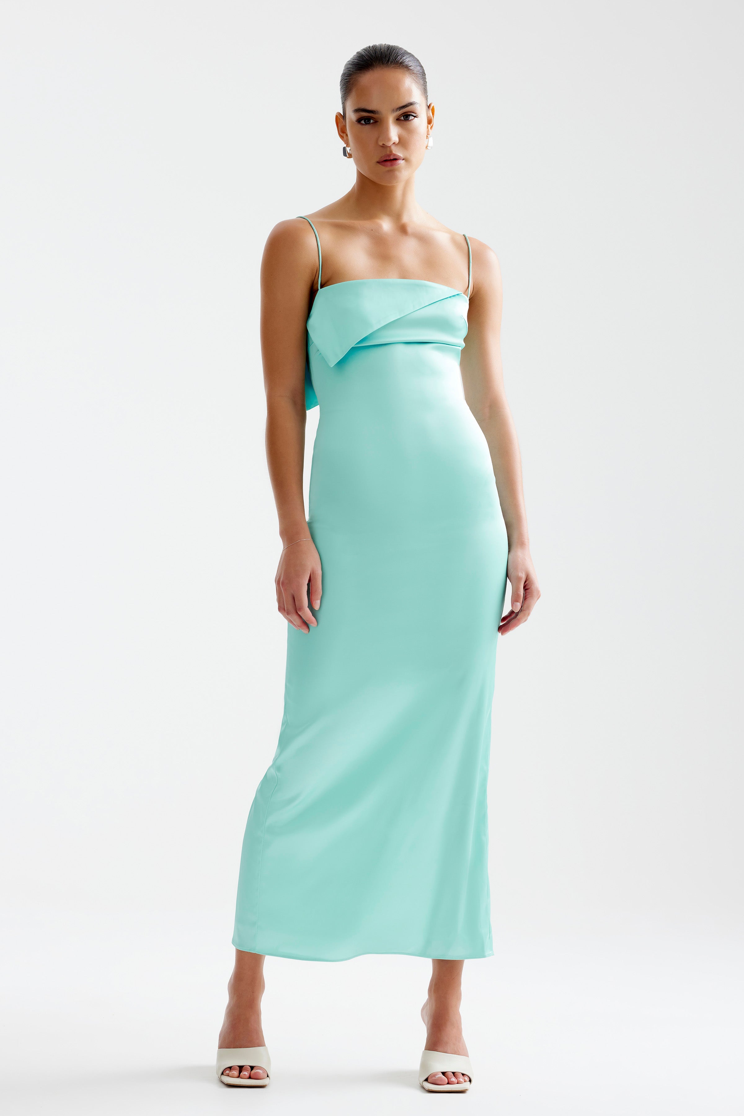 Rayna Dress featuring a fitted silhouette with thin straps and a modern folded neckline in aqua for formal events