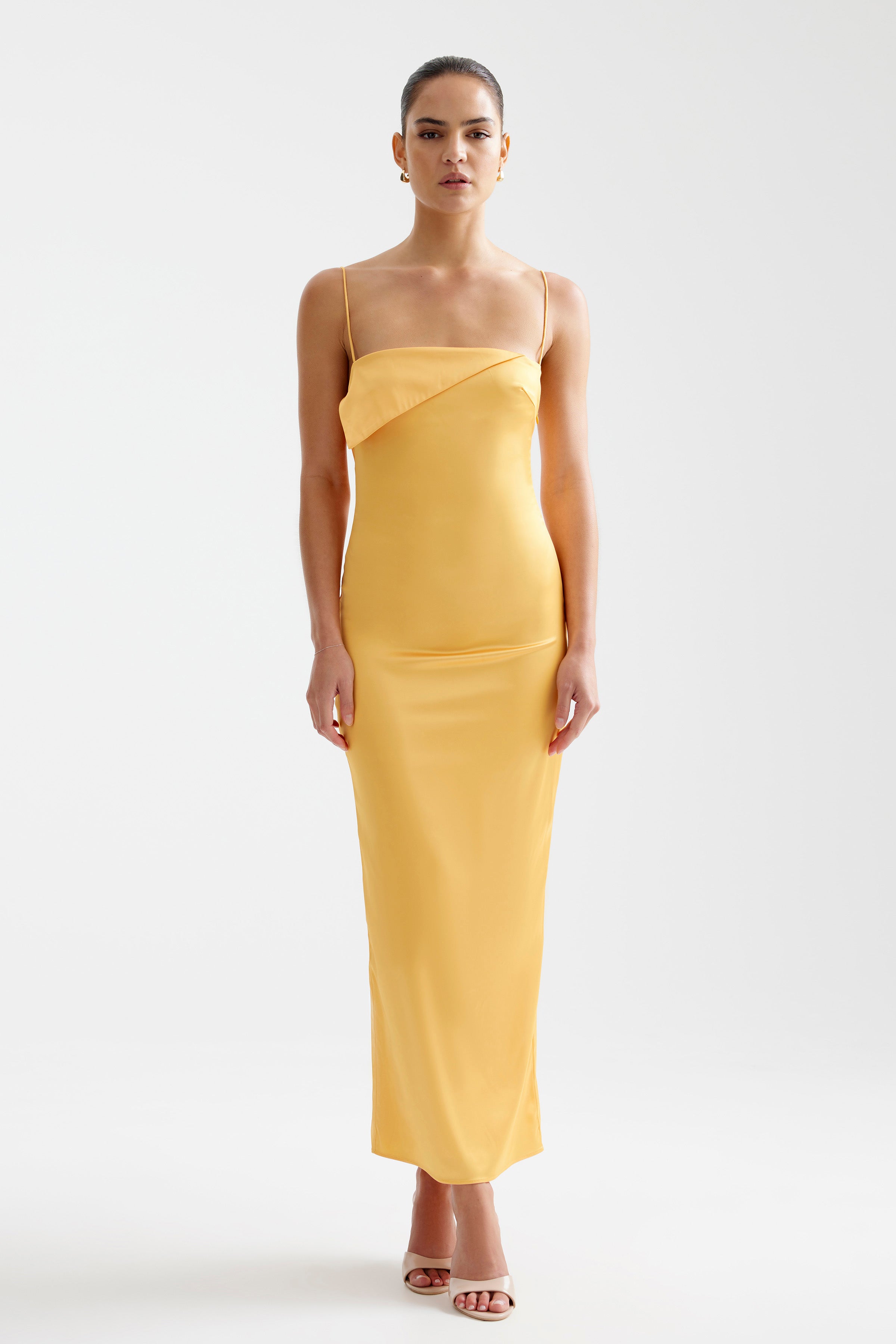 Rayna Dress features a sleek silhouette with thin straps and a folded neckline in papaya for formal and party occasions