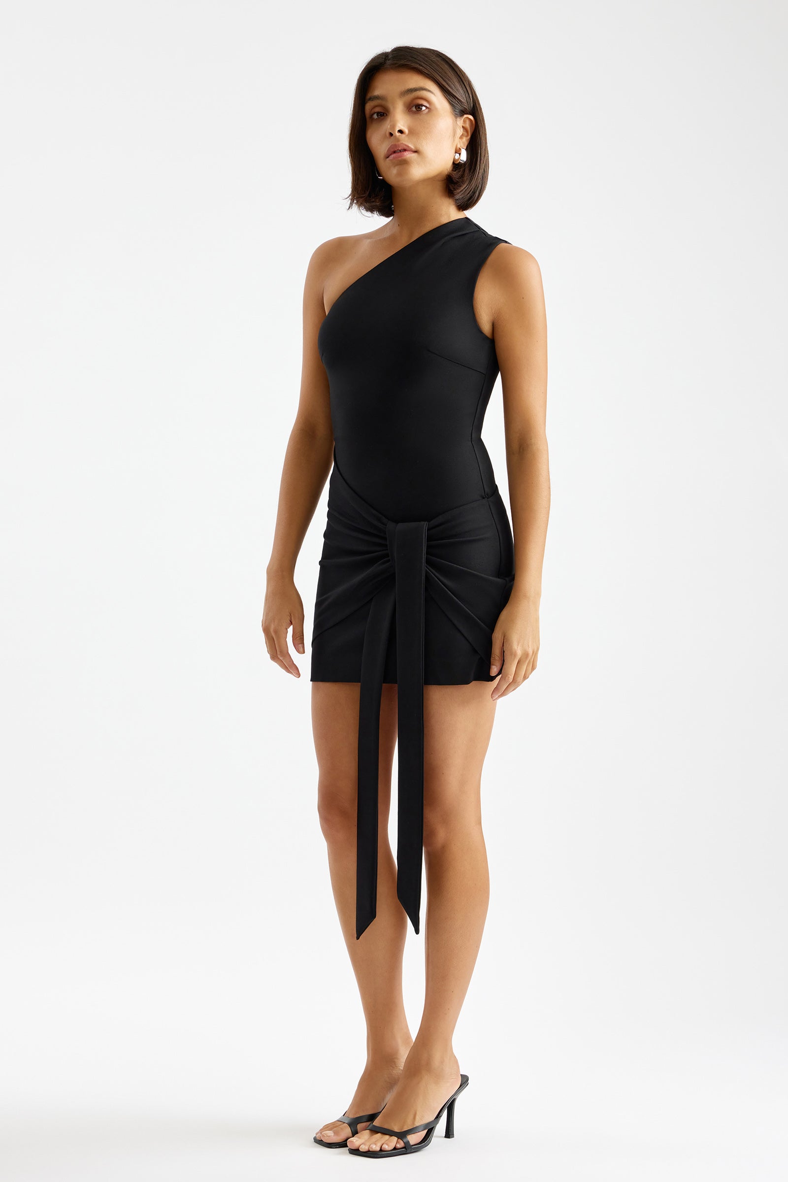 Shea Dress asymmetrical one-shoulder design with front tie detail in black for cocktail and party occasions by Studio Lexi