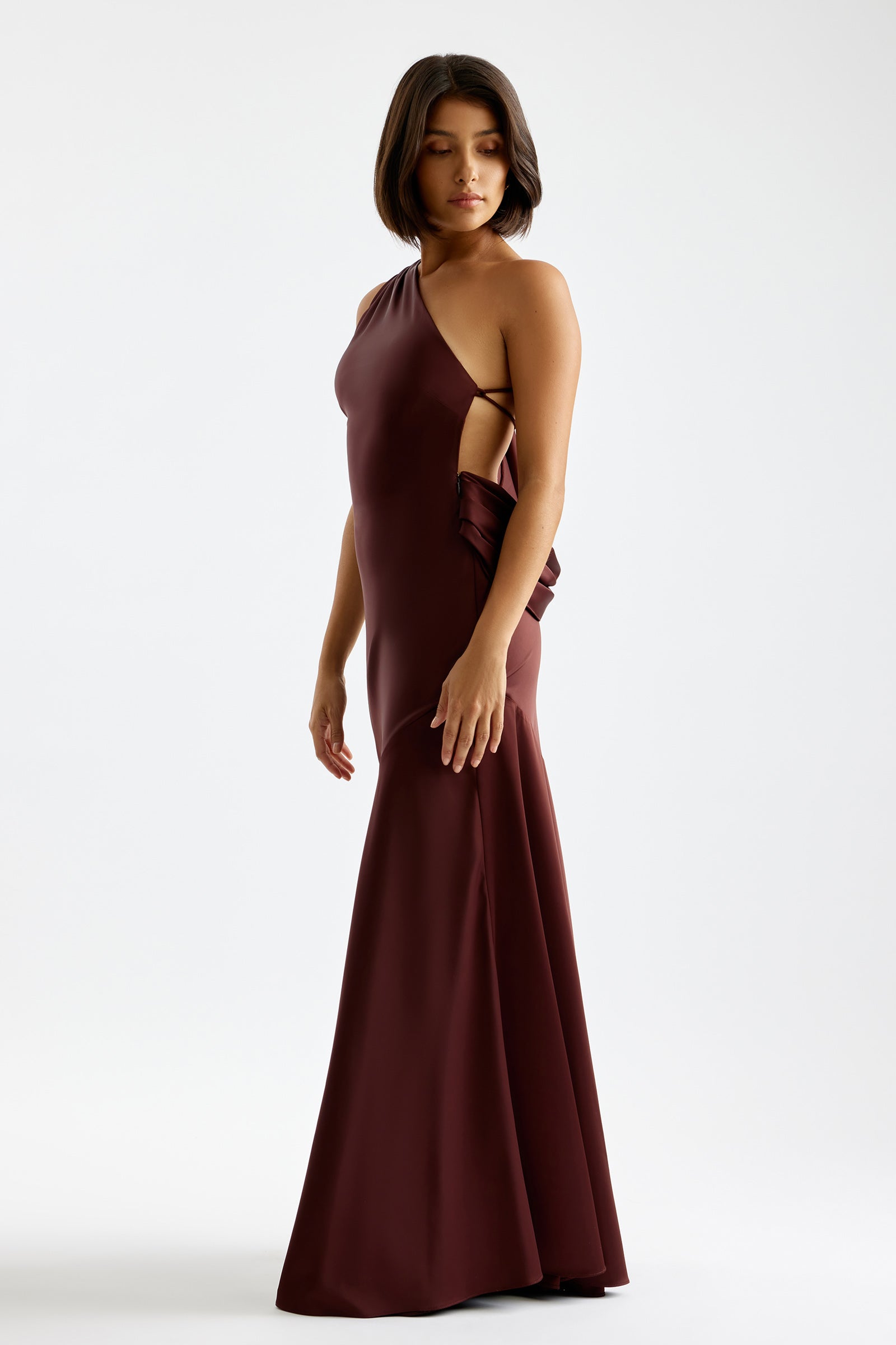 Tala Dress featuring an asymmetrical cut and backless design in deep plum for formal and wedding occasions by Studio Lexi