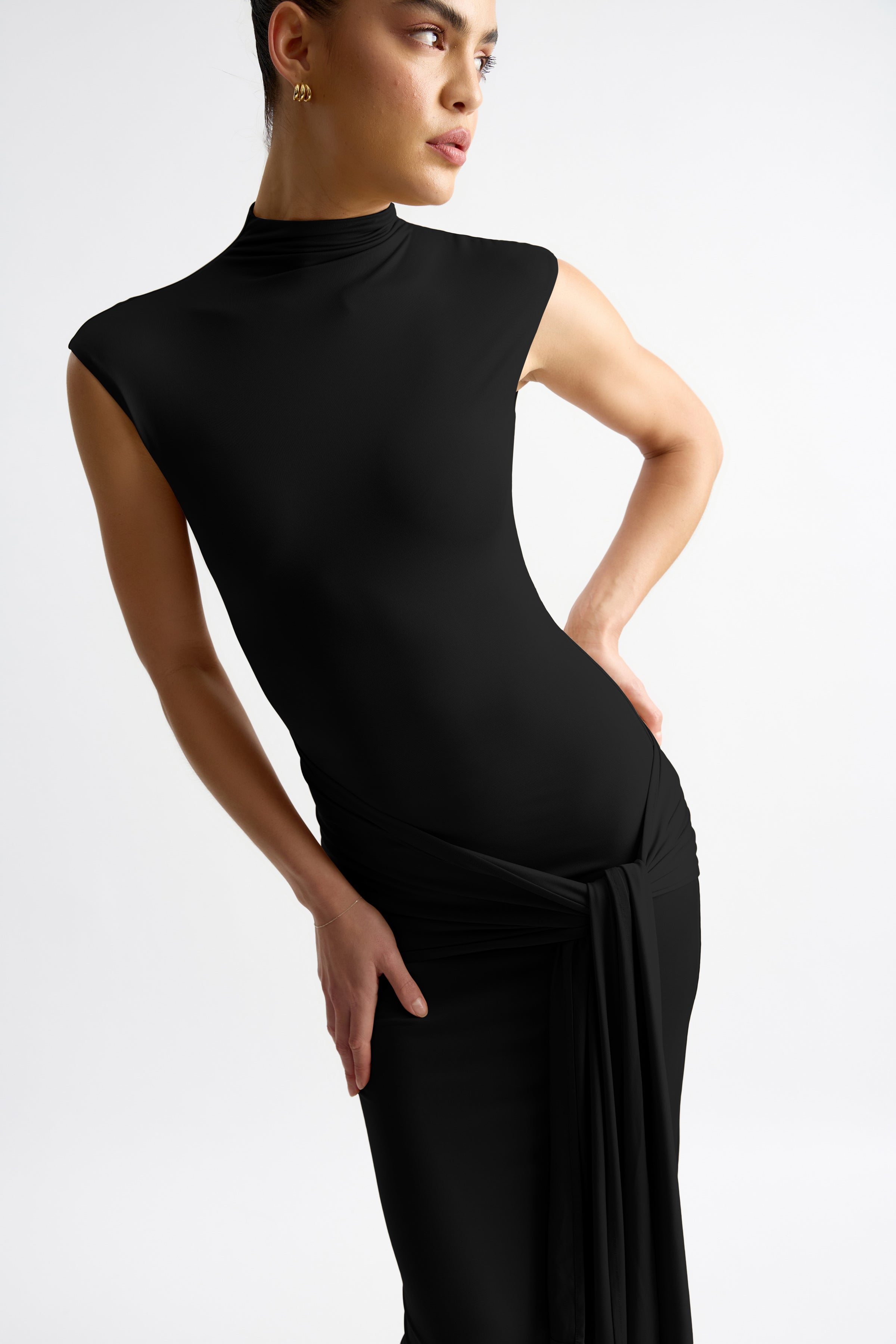 Thierry Dress featuring a fitted high neck silhouette with cap sleeves and waist tie detail in black by Studio Lexi