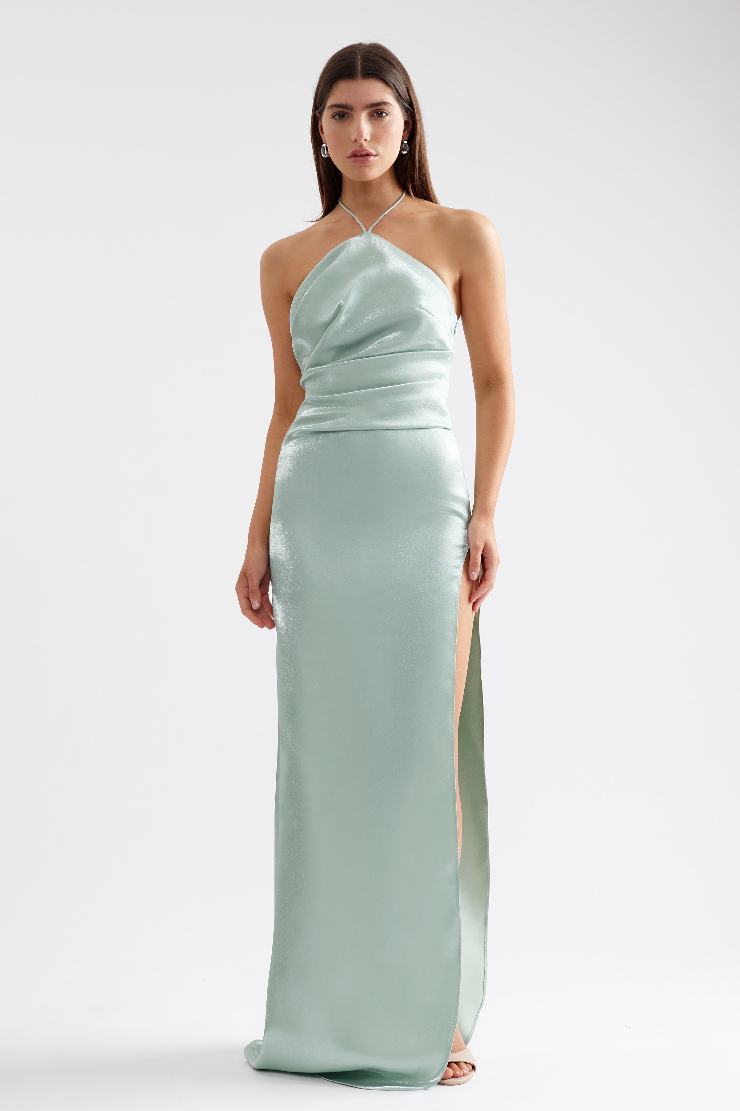 Vera Dress sleek halter gown with thigh-high split and small train in pistachio satin for formal and wedding guest occasions