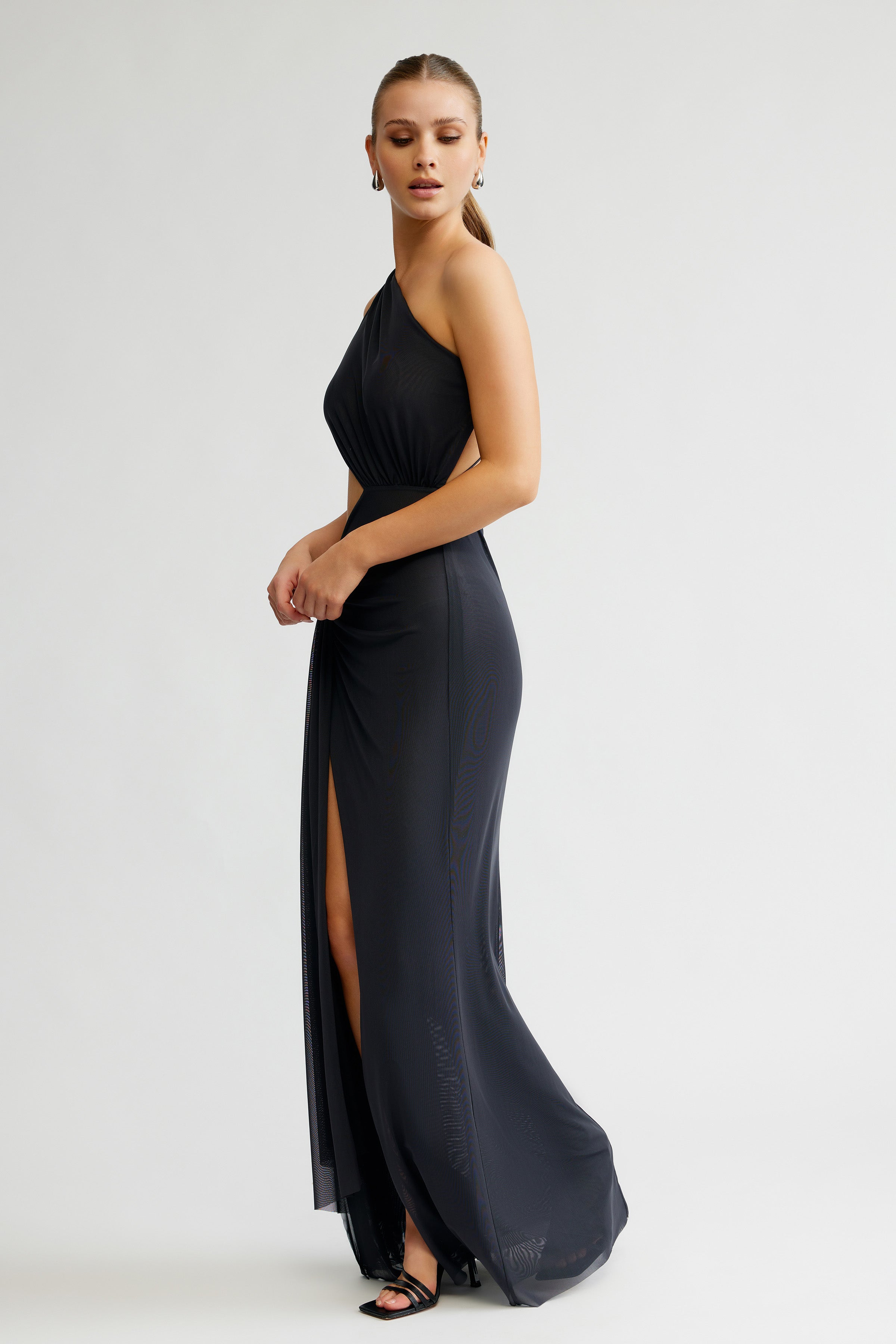 Zaniah Dress featuring a sleek one-shoulder silhouette with backless detail and high split in charcoal for formal occasions