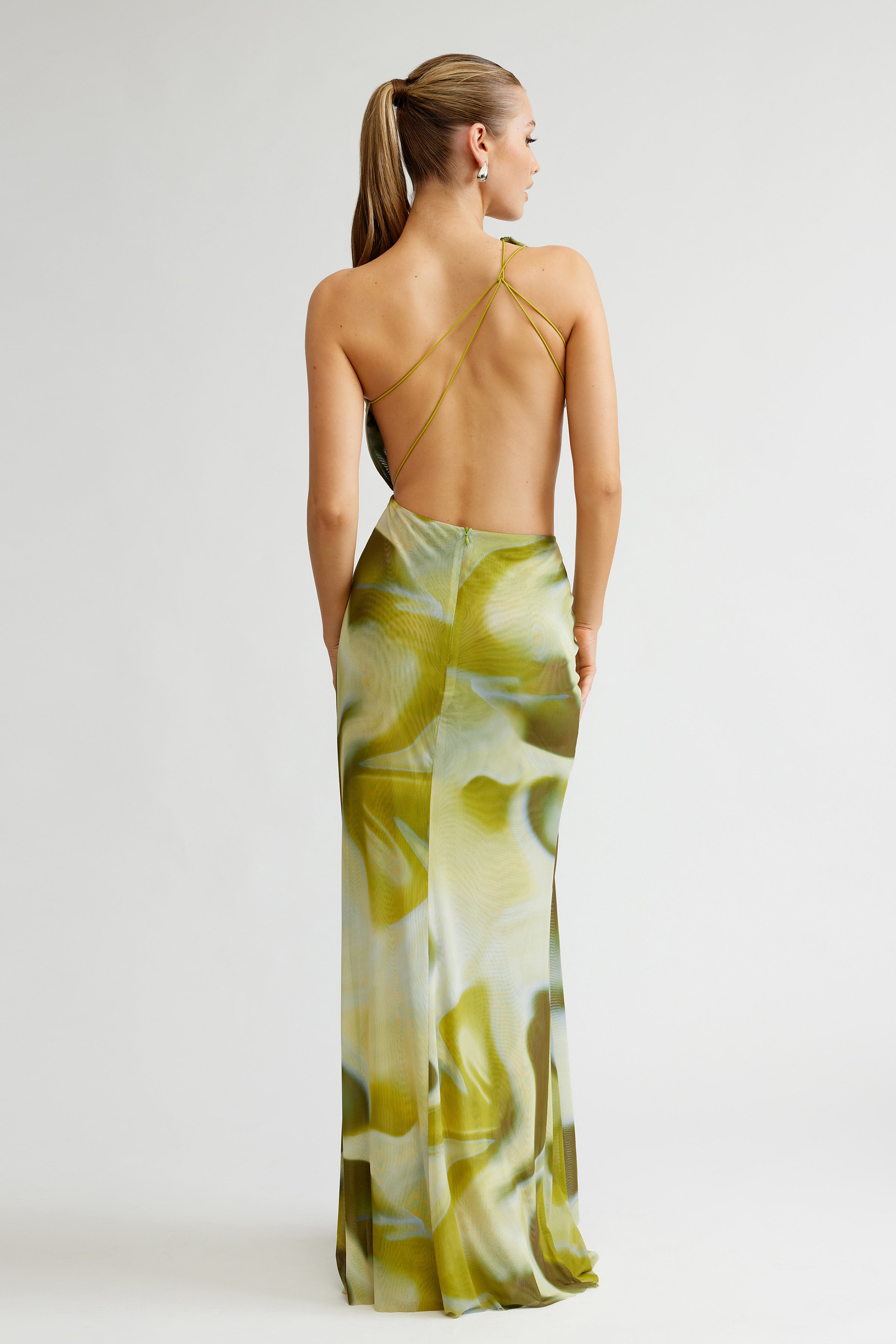 Zaniah Dress featuring a backless design with delicate straps and fluid sage liquify print for formal occasions