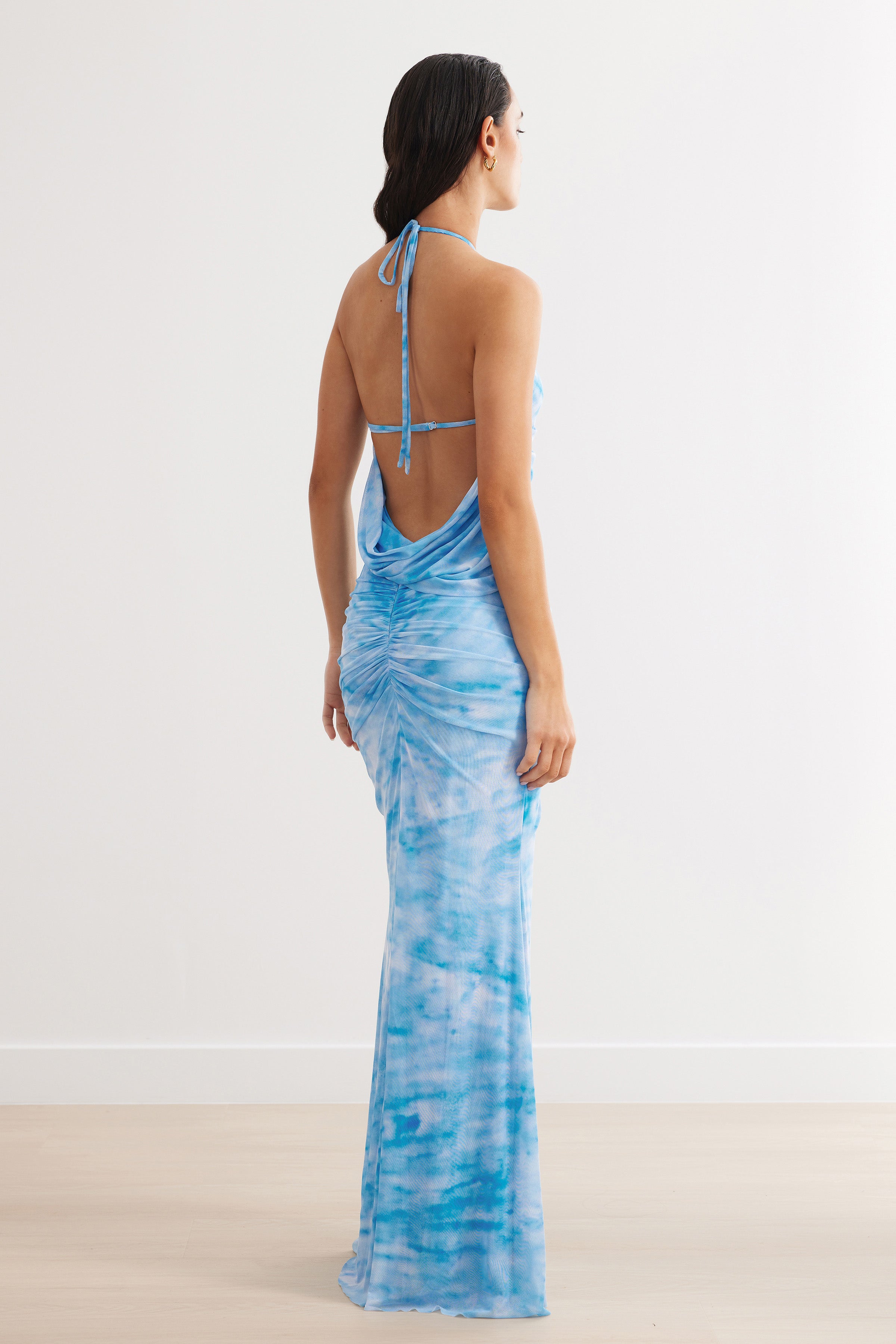 Amber Dress featuring a backless design with ruched detailing and split hem for elegant formal and wedding guest occasions in blue print