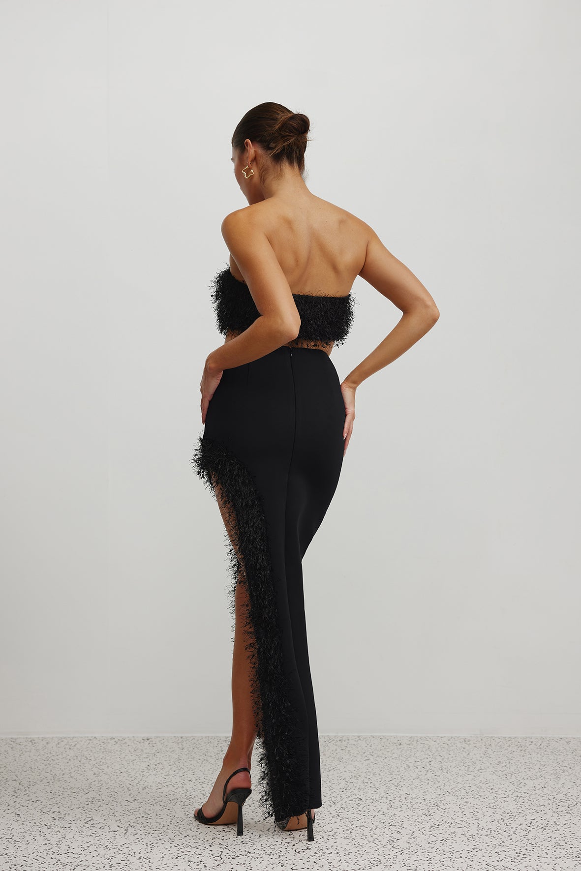Margarita Set featuring a backless design with feather trim and high side split in black for formal occasions