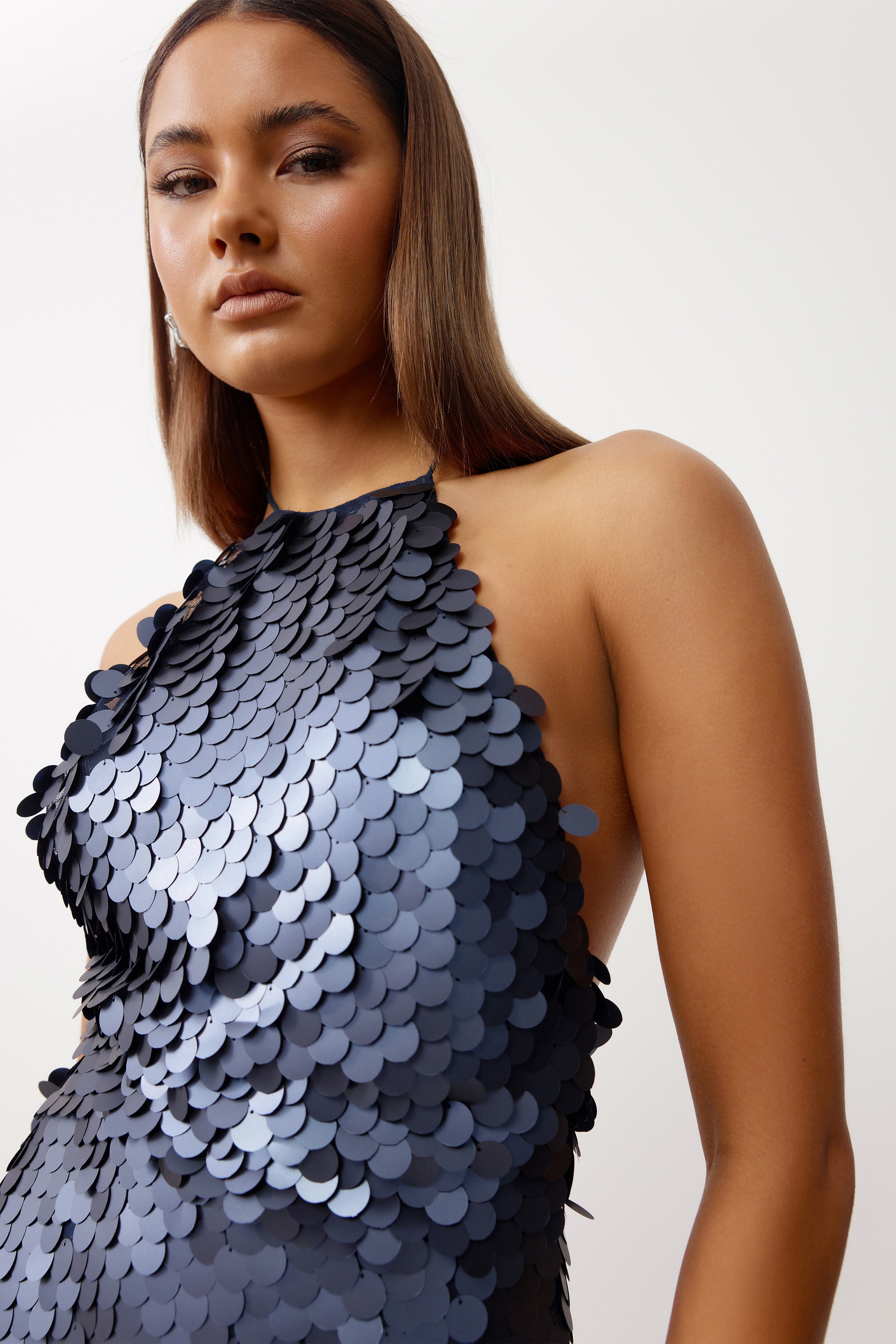 Mira Dress featuring large sequins, a halter neckline, and backless design in deep midnight black for cocktail events